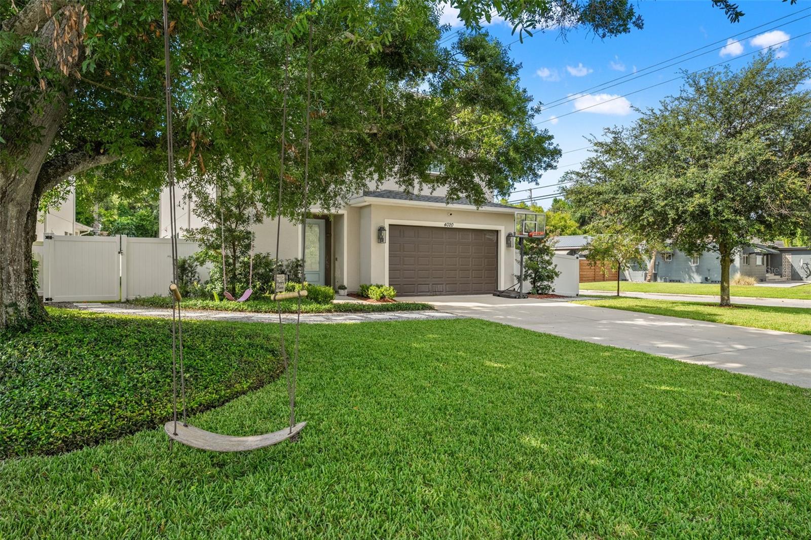 Expansive yard with a tree swing and lush greenery, offering both charm and outdoor enjoyment.