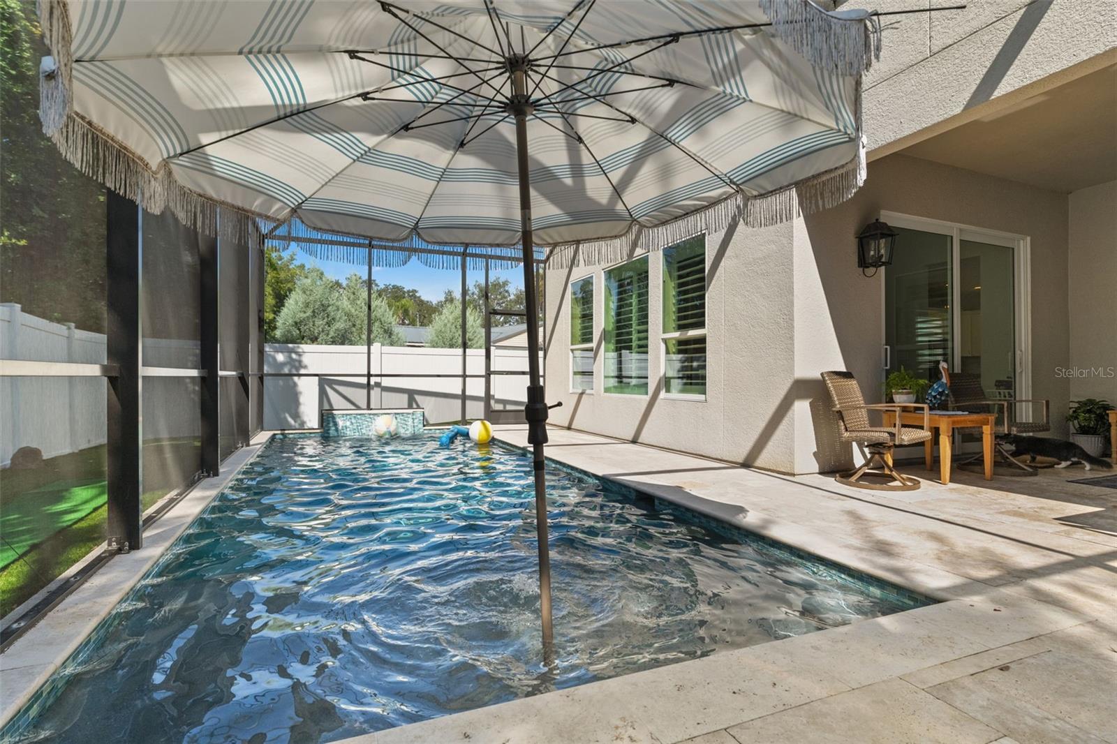 Relaxing retreat with shaded lounge area and views of the sparkling pool.
