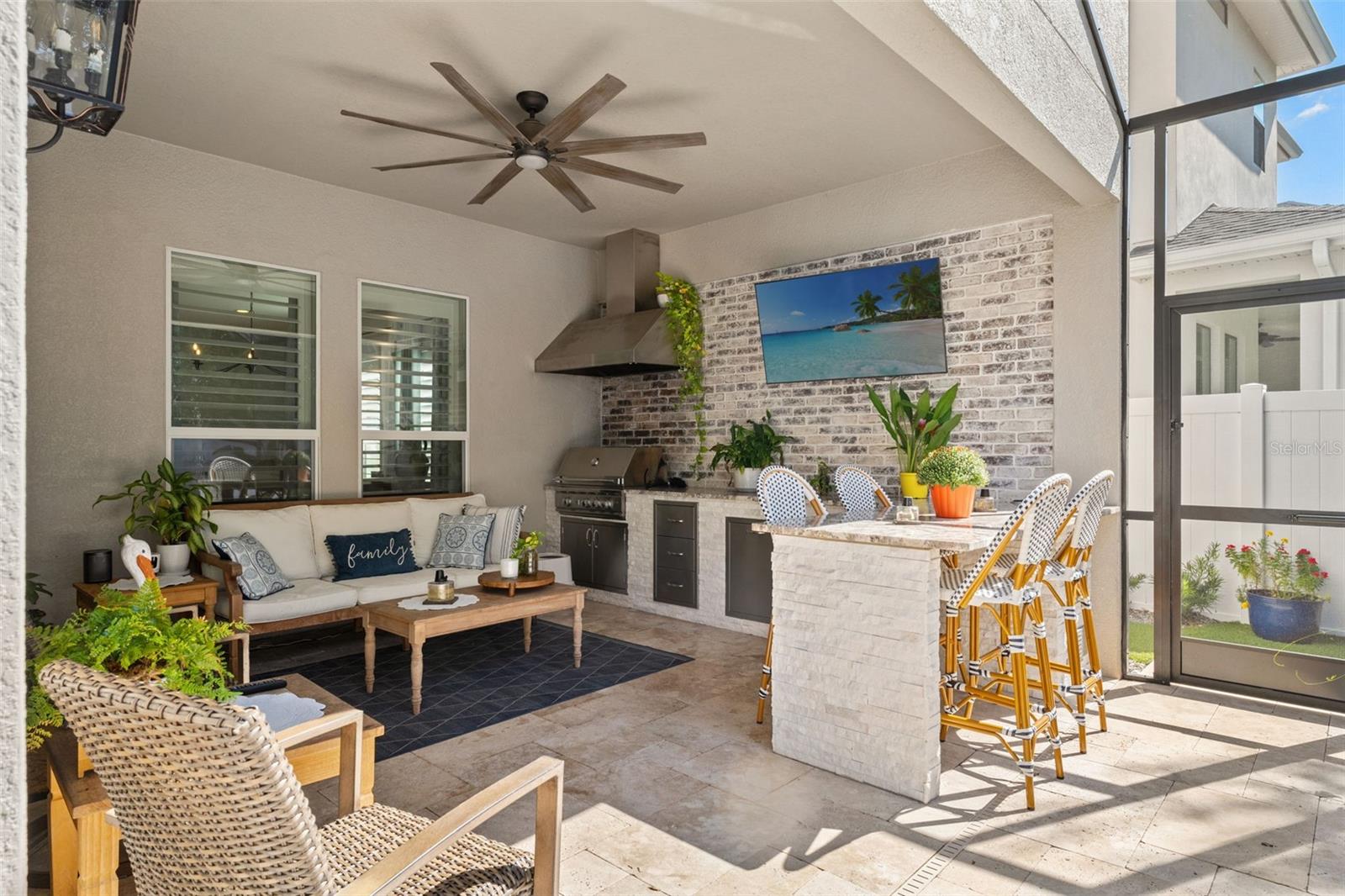 Covered retreat with grilling station, ceiling fan, and plenty of room for relaxation or dining.