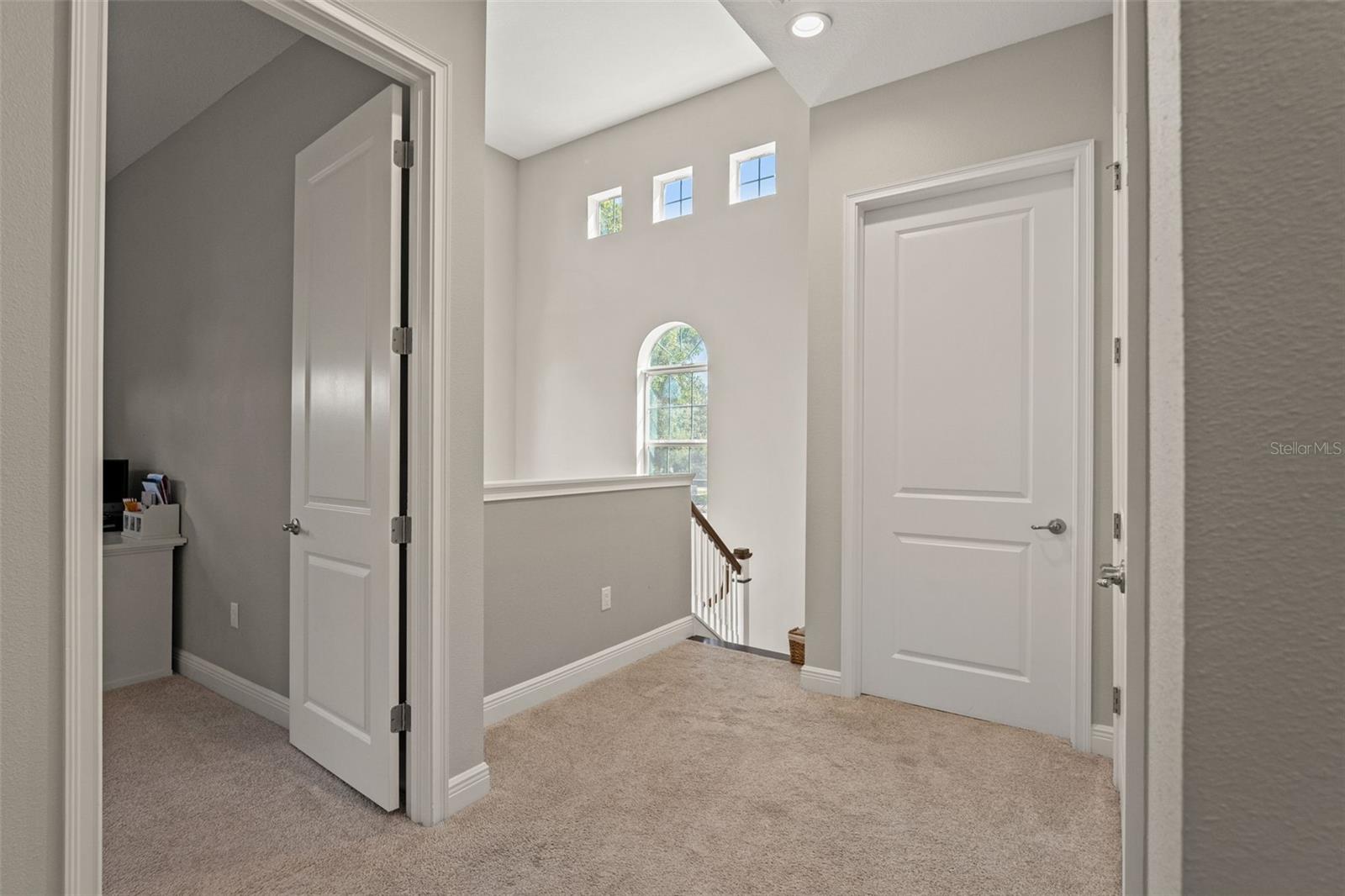 Bright landing with multiple windows, providing natural light and access to secondary bedrooms.