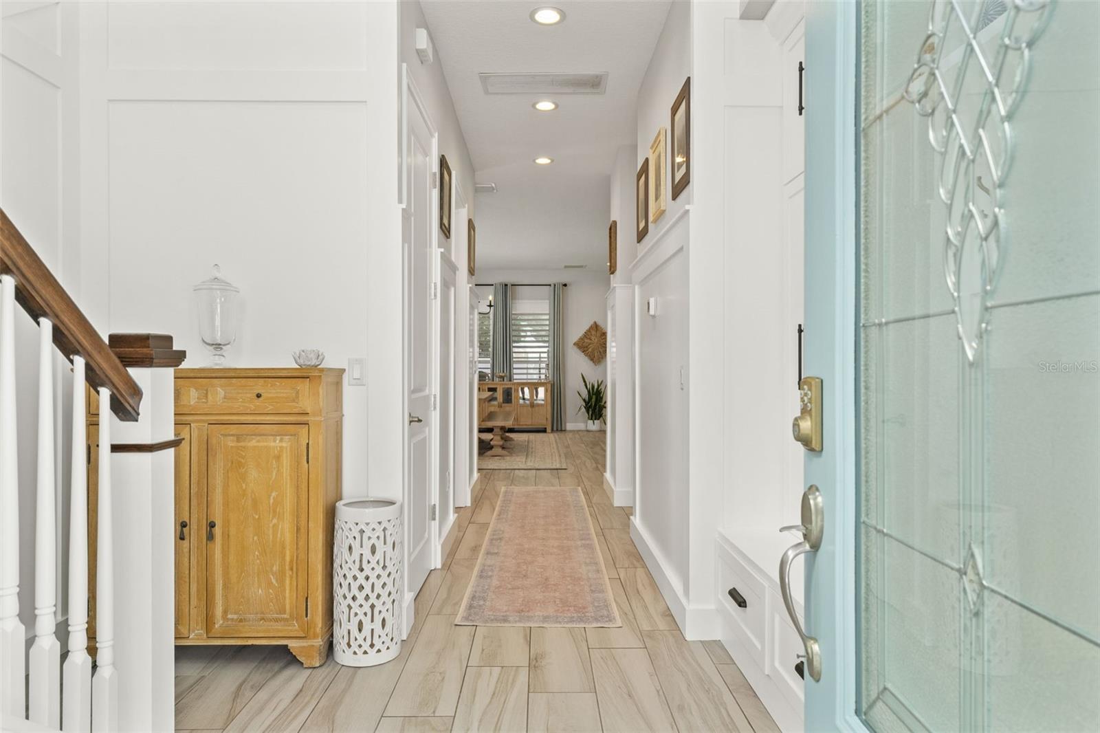 Bright hallway with wood-look tile floors and custom trim work, setting the tone for the home’s stylish interior.