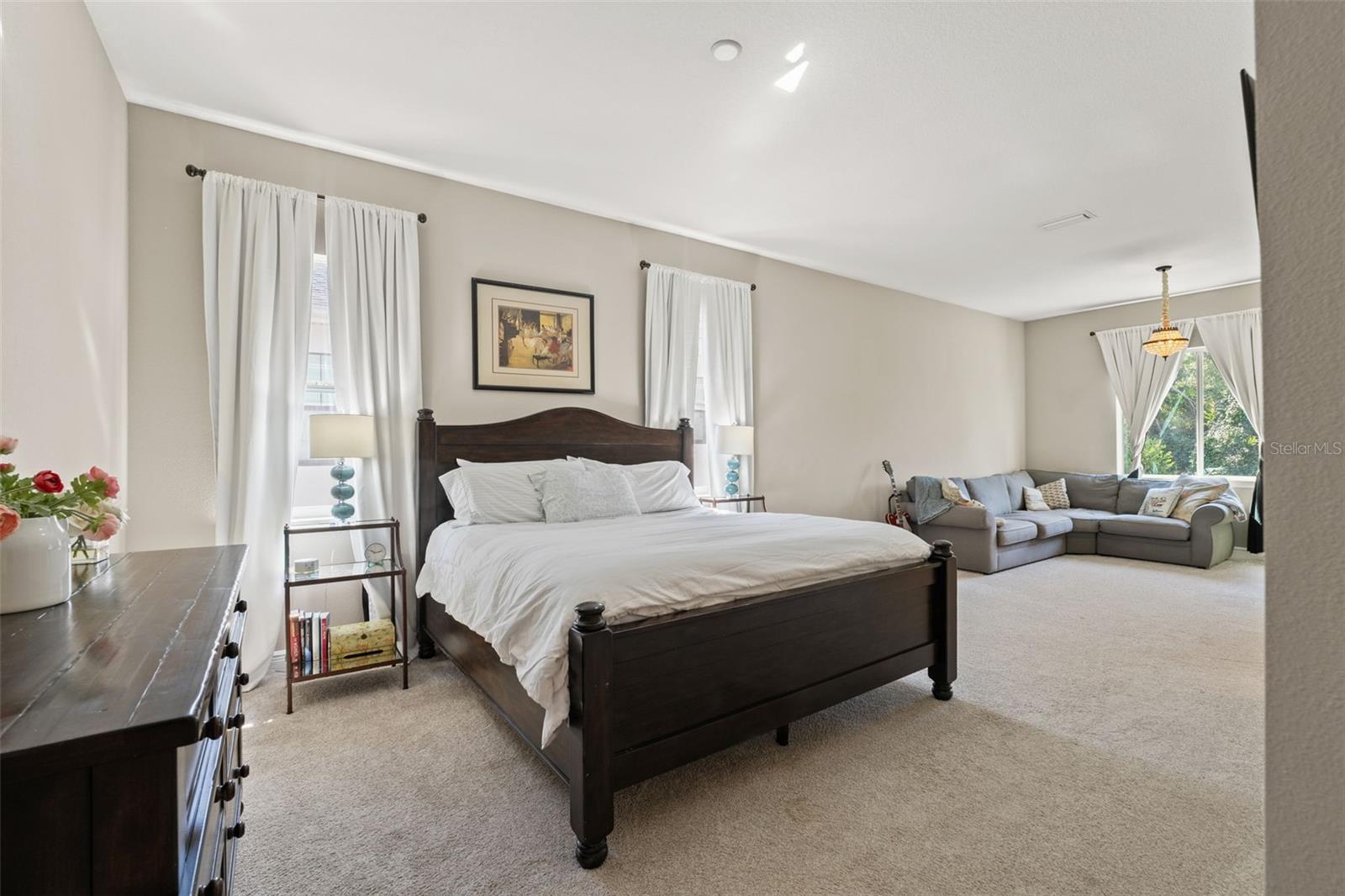 Expansive suite with room for a full bedroom set and sitting area, enhanced by natural light and tall windows.