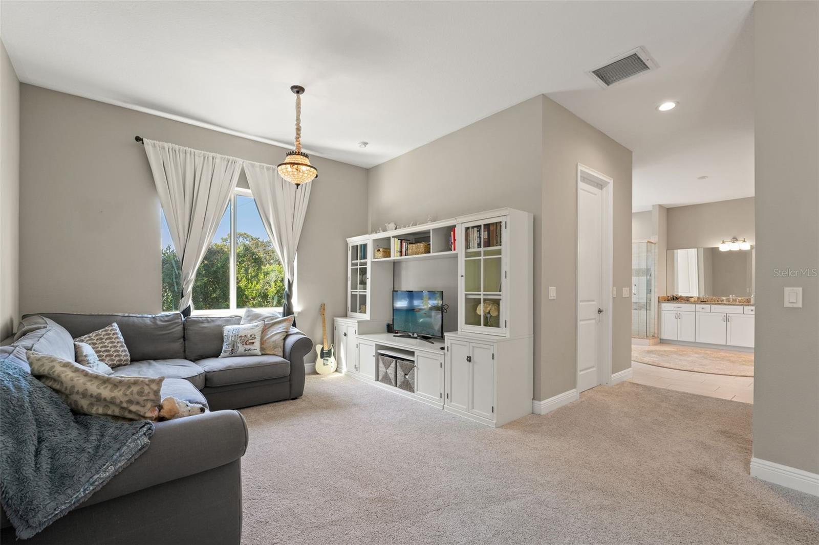 Generous sitting space with built-in cabinetry and direct access to the spa-like bathroom.