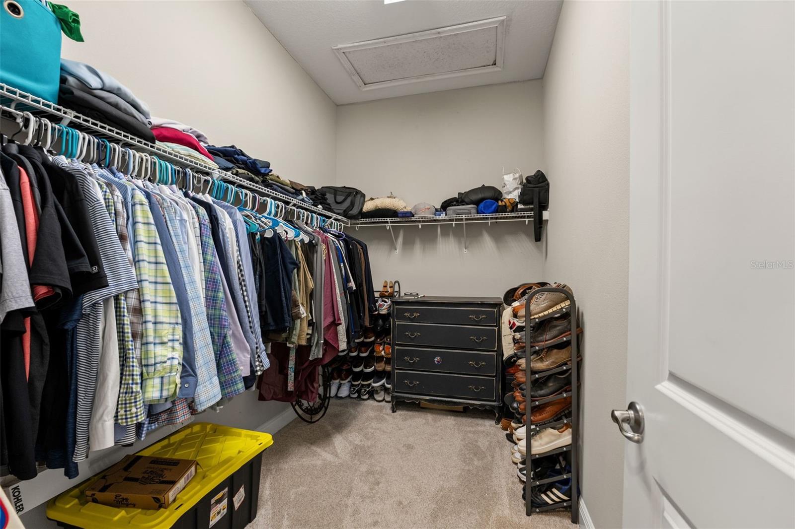 Walk-in closet with hanging racks and shelving, providing ample storage.