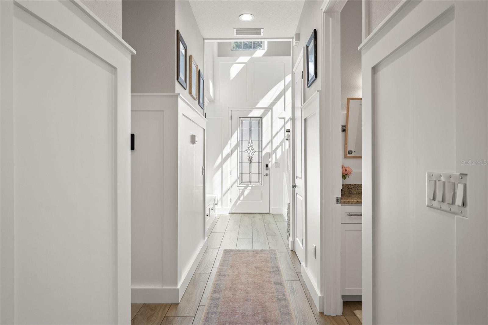 Crisp white trim and board-and-batten details create a polished transition from the entry to the main living areas.