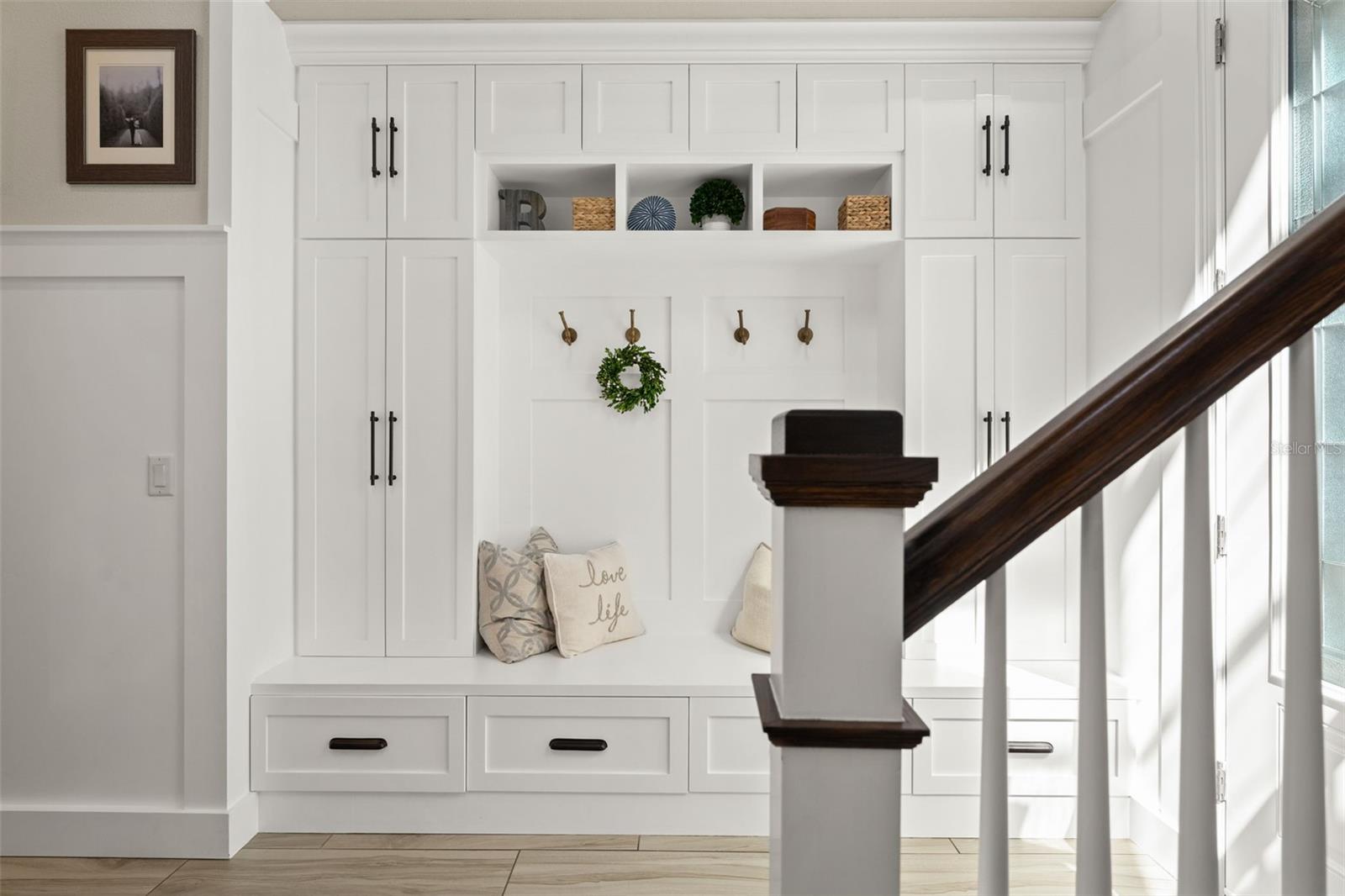 Functional built-in cabinetry with hooks, storage drawers, and seating, perfect for everyday organization.