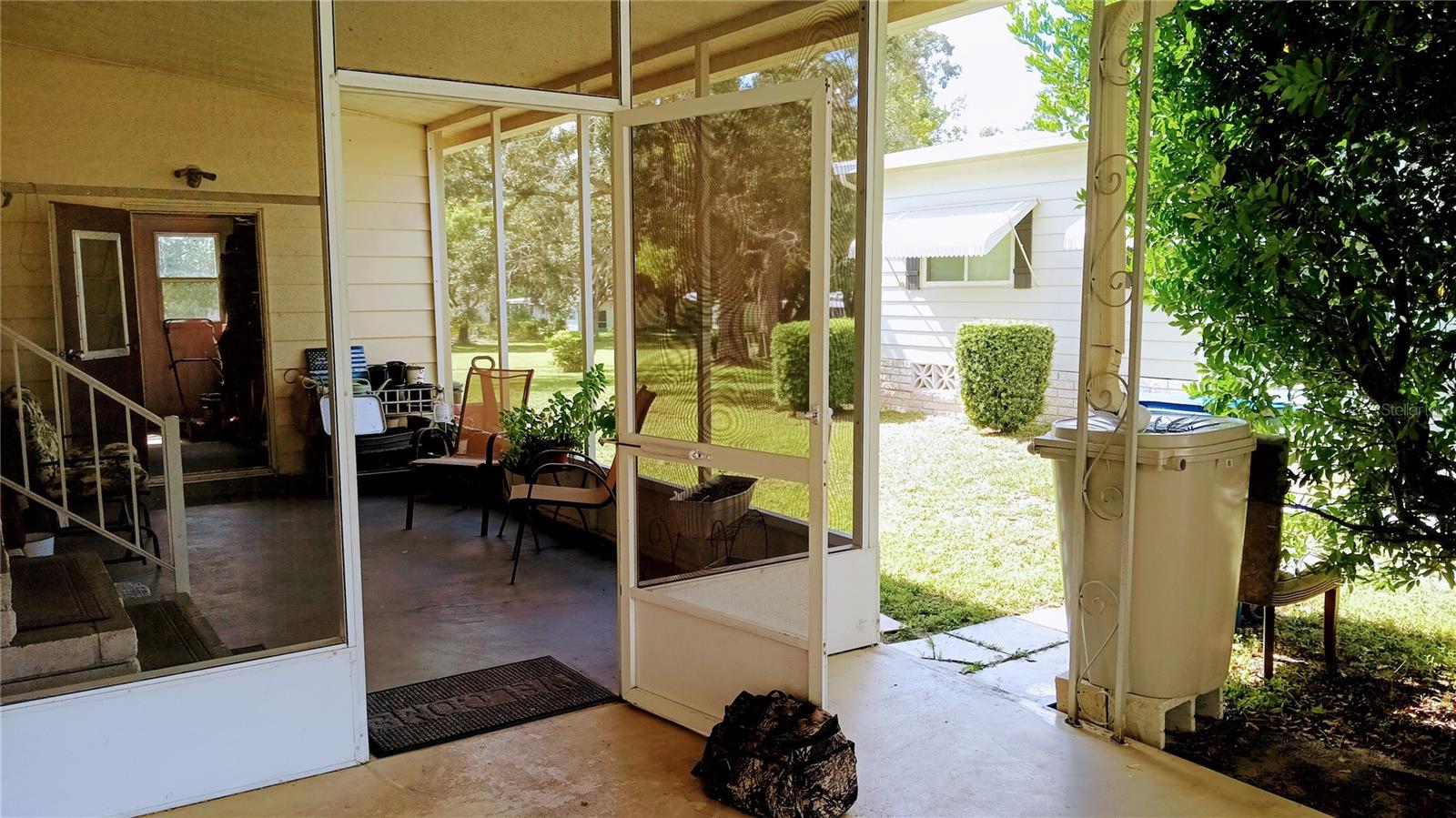 Screen porch with entrance to home and Golf Cart Garage and Laundry.