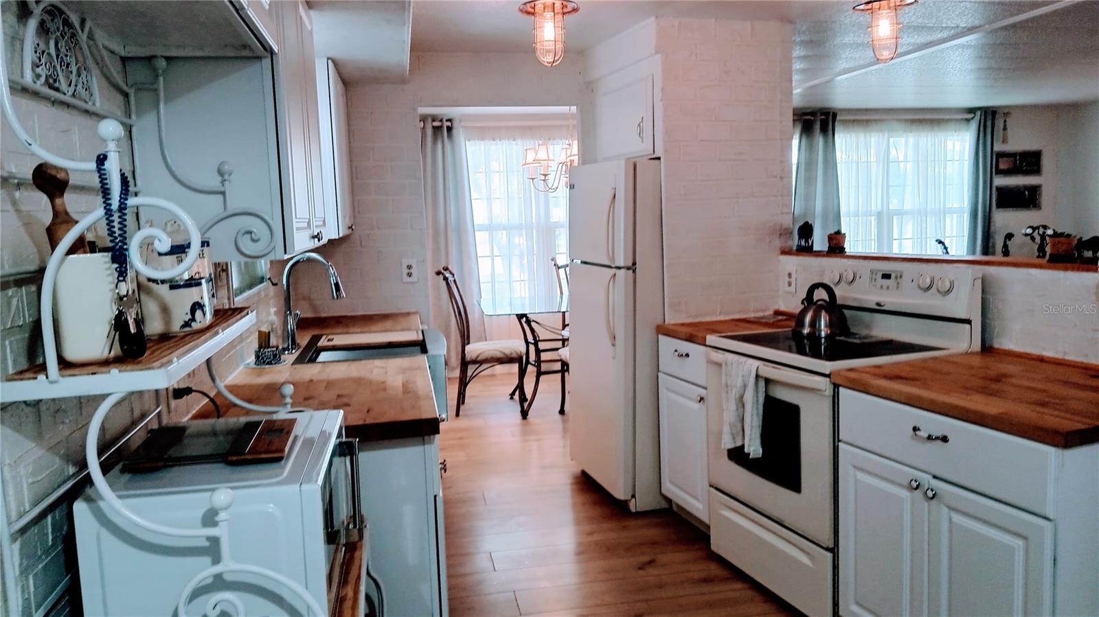 Recently remodeled kitchen with butcher block countertops, solid wood cabinets, and farmer's deep sink with built in dish drainer and cutting board