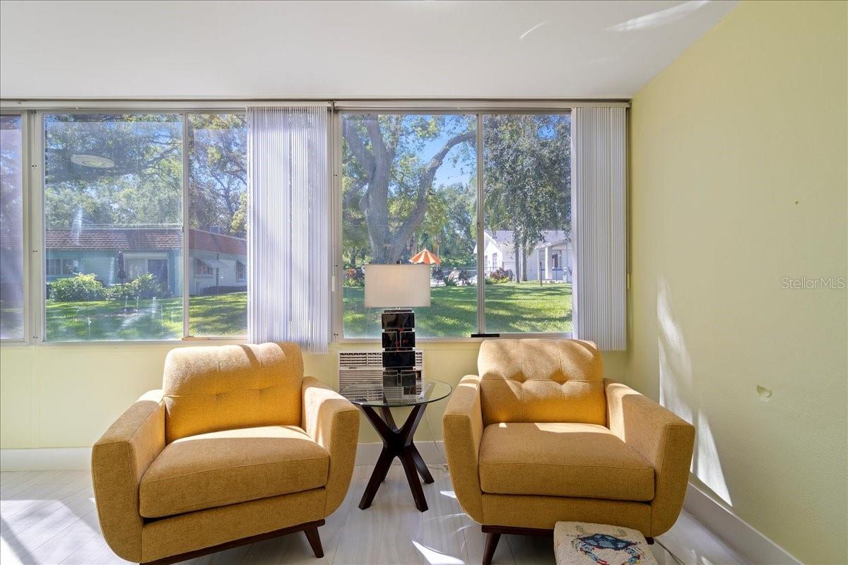 finished lanai/sunroom, where large windows stretch across the back of the unit, filling the space with natural light and framing tranquil views of mature oak trees and greenspace. Complete with a storage closet, this inviting area offers the perfect place to relax and unwind.