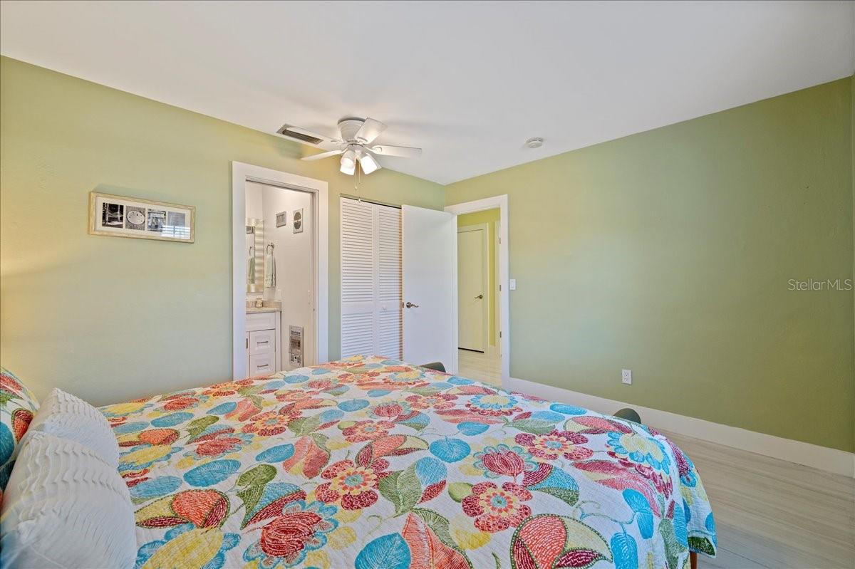 The bedroom is tucked away for privacy and includes a walk-in closet and an updated ensuite bathroom with a beautifully tiled shower and a stylish vanity with a granite countertop.