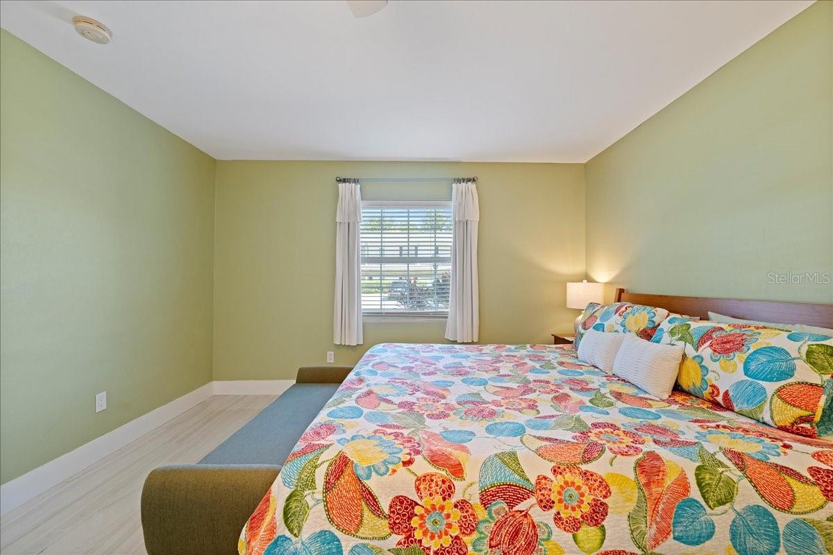 The bedroom is tucked away for privacy and includes a walk-in closet and an updated ensuite bathroom with a beautifully tiled shower and a stylish vanity with a granite countertop.
