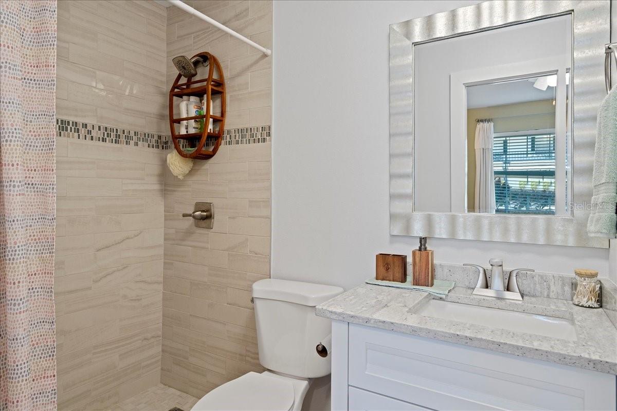 Updated ensuite bathroom with a beautifully tiled shower and a stylish vanity with a granite countertop