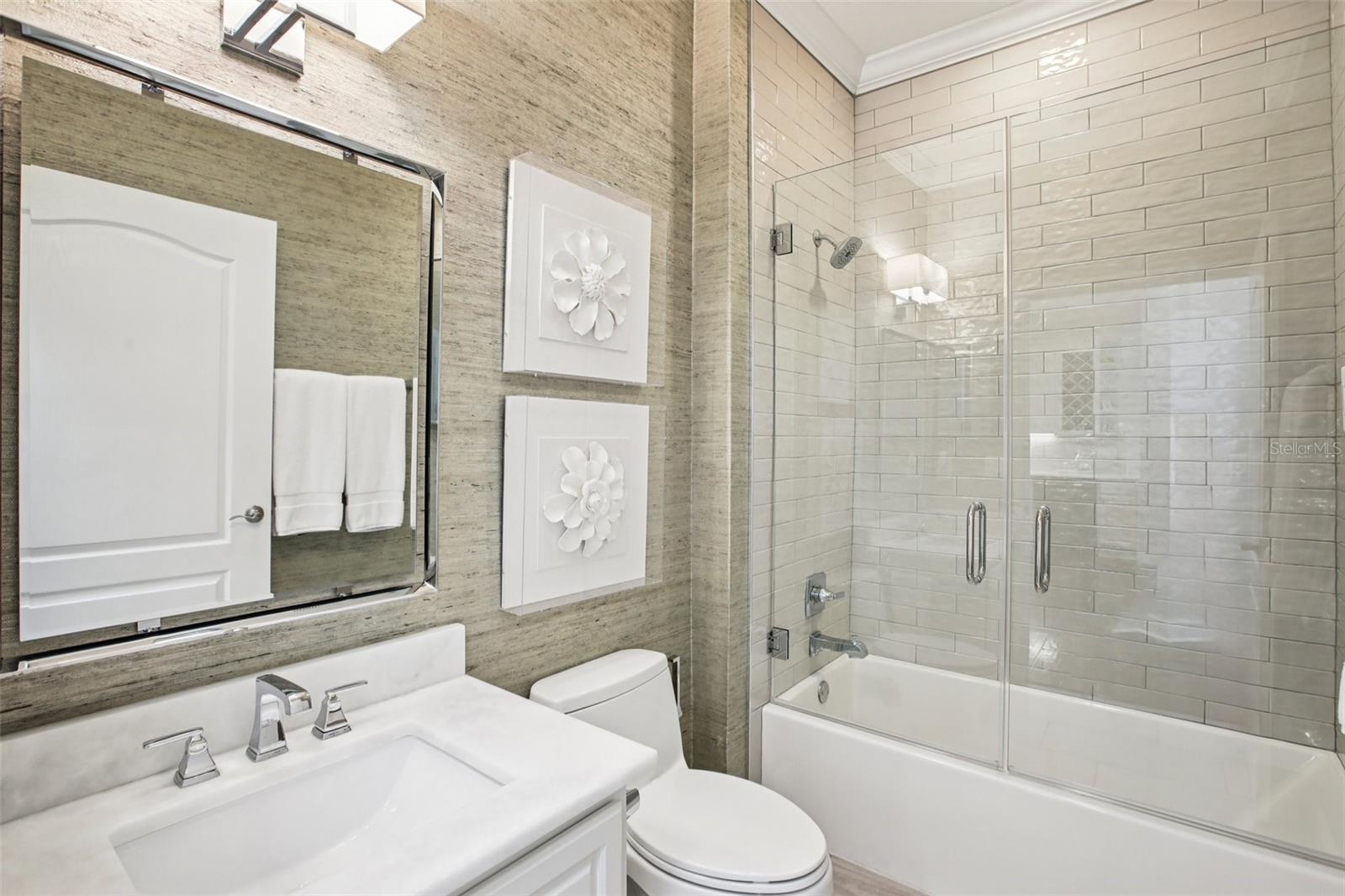 Bathroom 2 has glass doors on the tub/shower combo, marble vanity, crown moulding