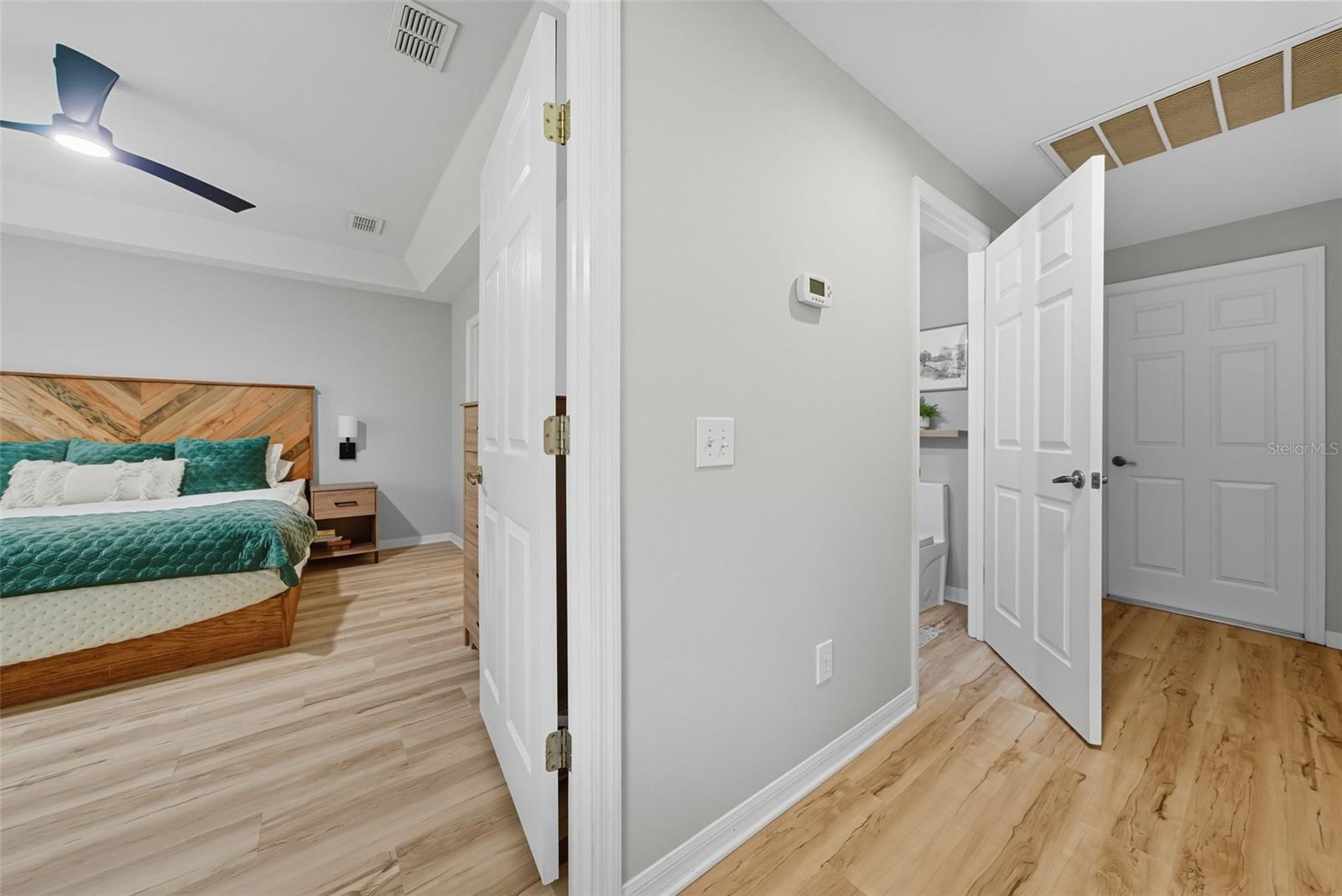 Hallway leading to the garage with a half bath, laundry closet & additional closet space