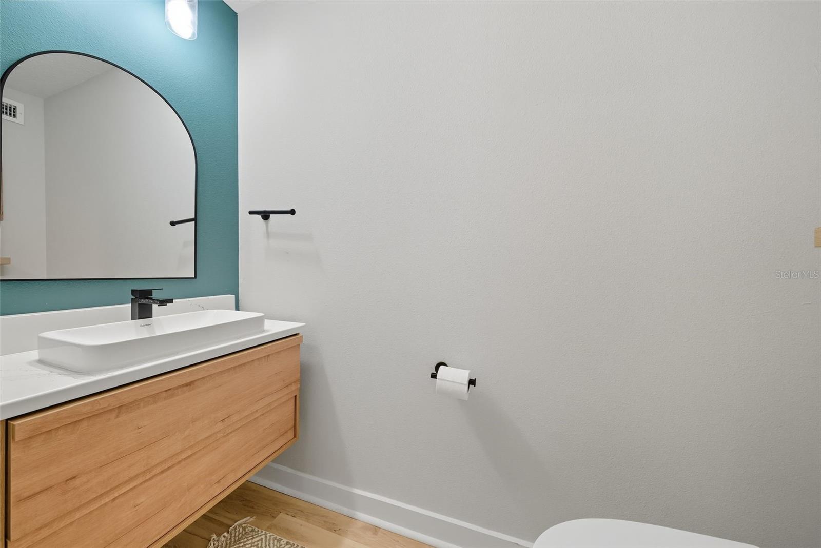 Updated half bath downstairs with new paint, toilet, vanity & light fixture