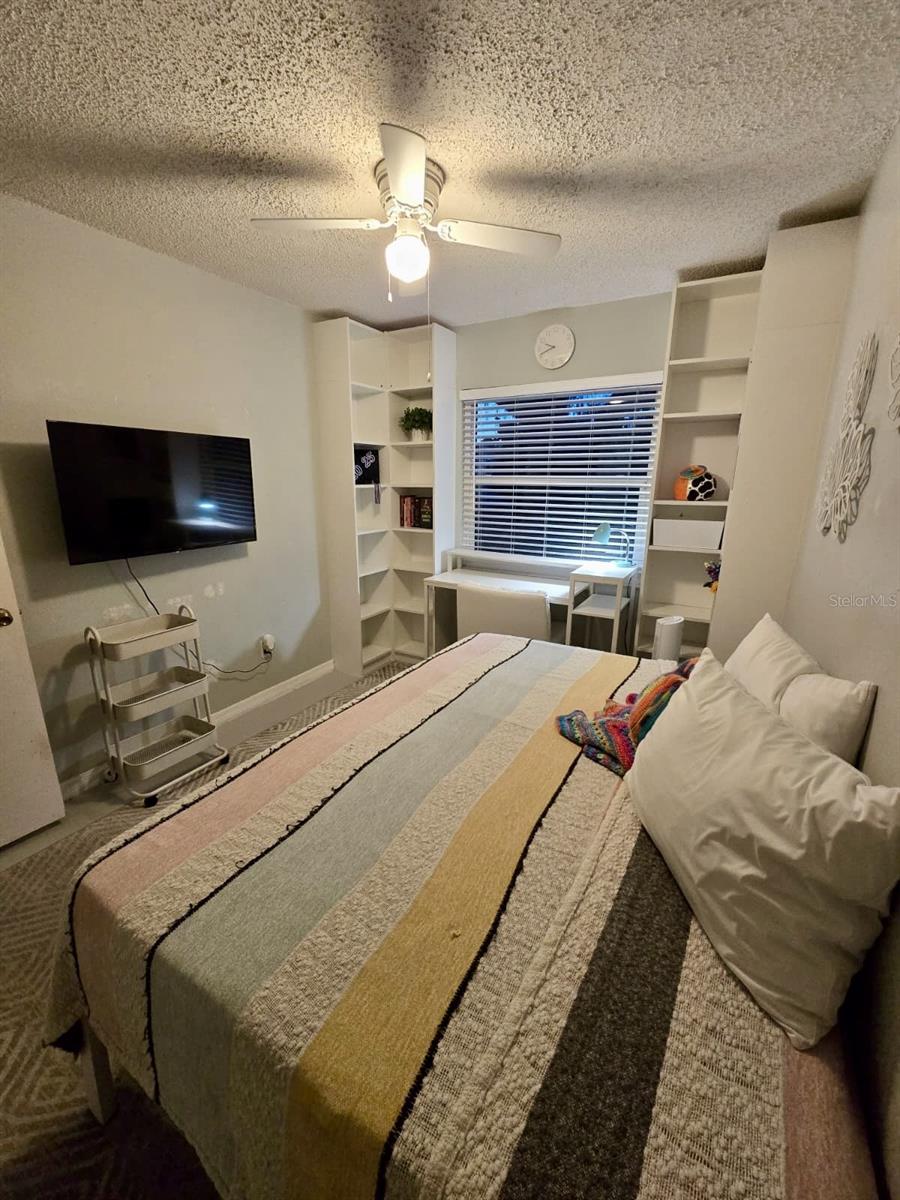 Second bedroom with floor to ceiling bookcases, creating a bright and cheery desk area or makeup table area!