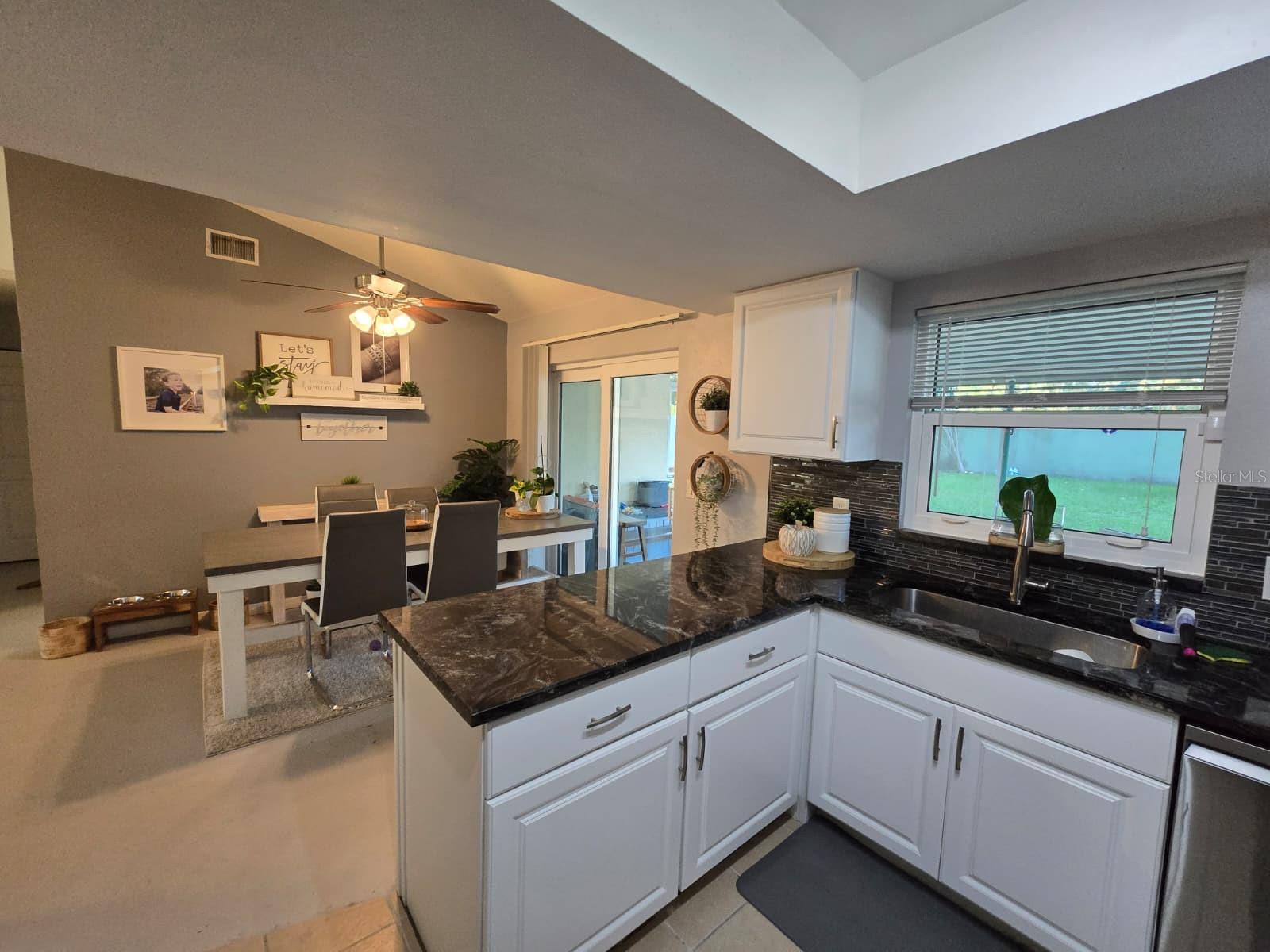 Remodeled kitchen with white cabinets and stainless steel appliances