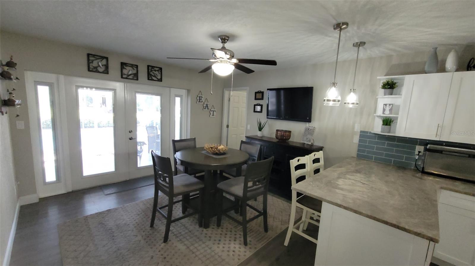 Heading back into the kitchen from the laundry, is a dining area as well as the doors to the pool and the door to the Primary Suite!