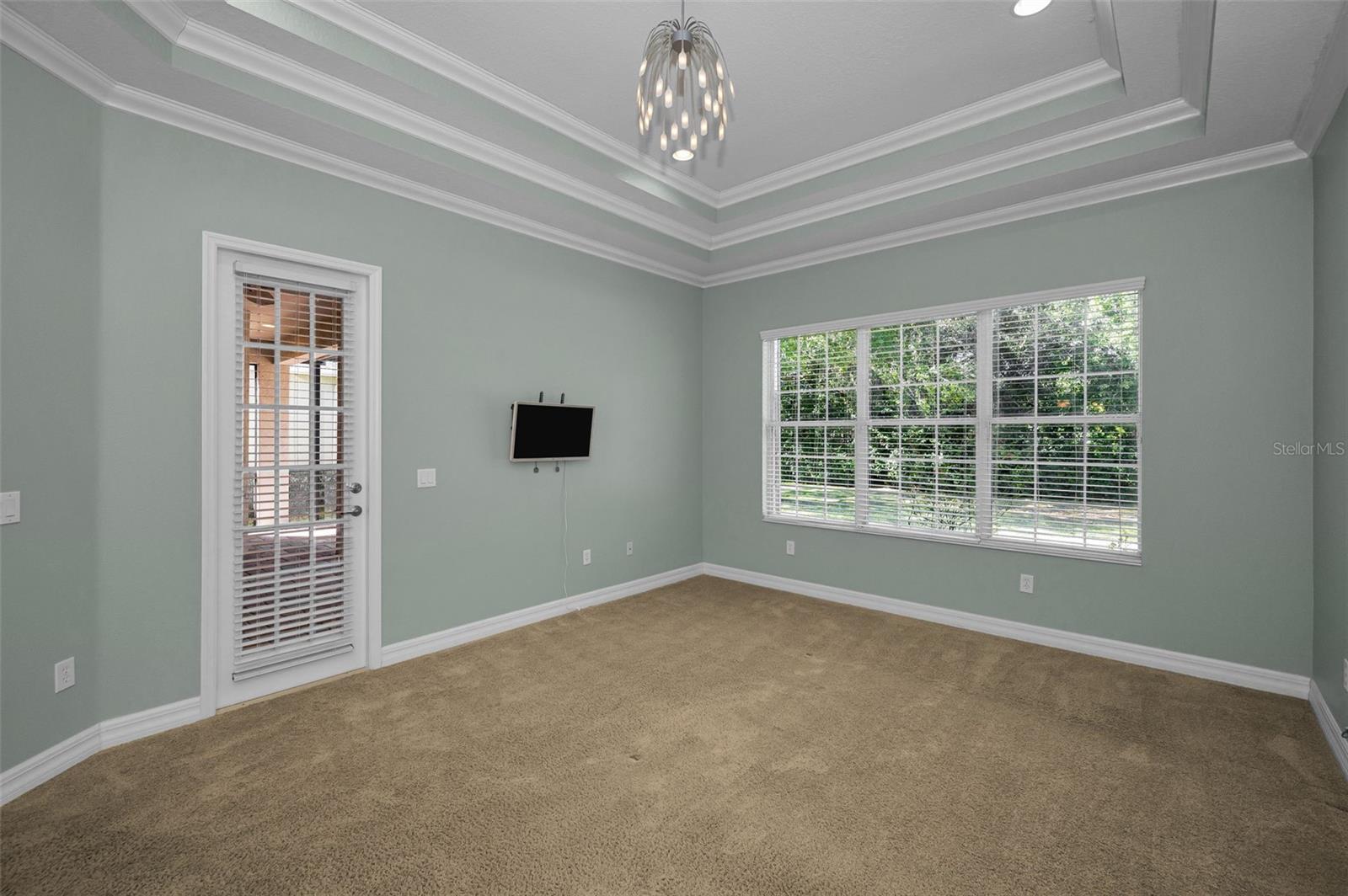 Primary bedroom with double tray ceilings and french door to lanai