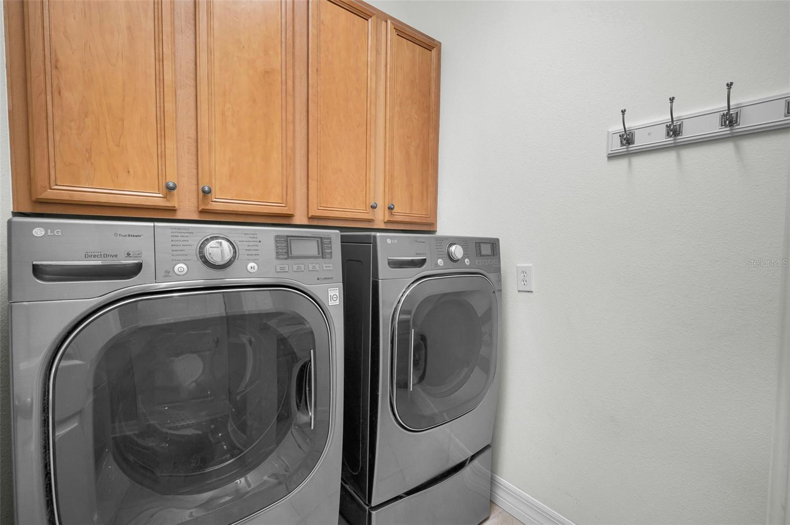 Laundry room compete with washer & dryer, storage cabinets and utility sink