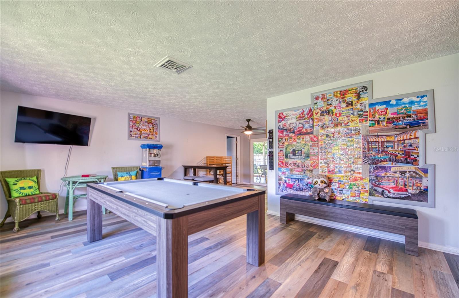Living room be used as a game room, pool table, dart board, puzzles, popcorn machine and puzzle wall
