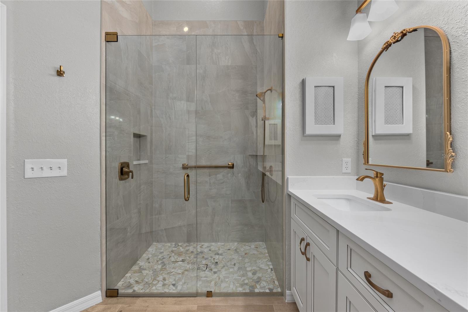 Check out this beautiful tiled shower with stylish gold fixtures