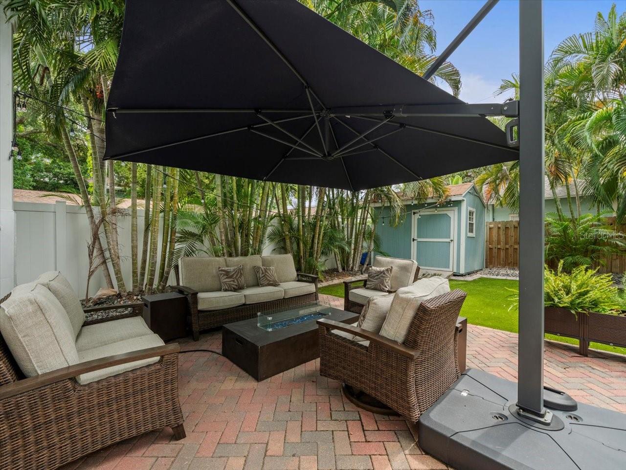 Back yard with paved patio/covered area and view of shed