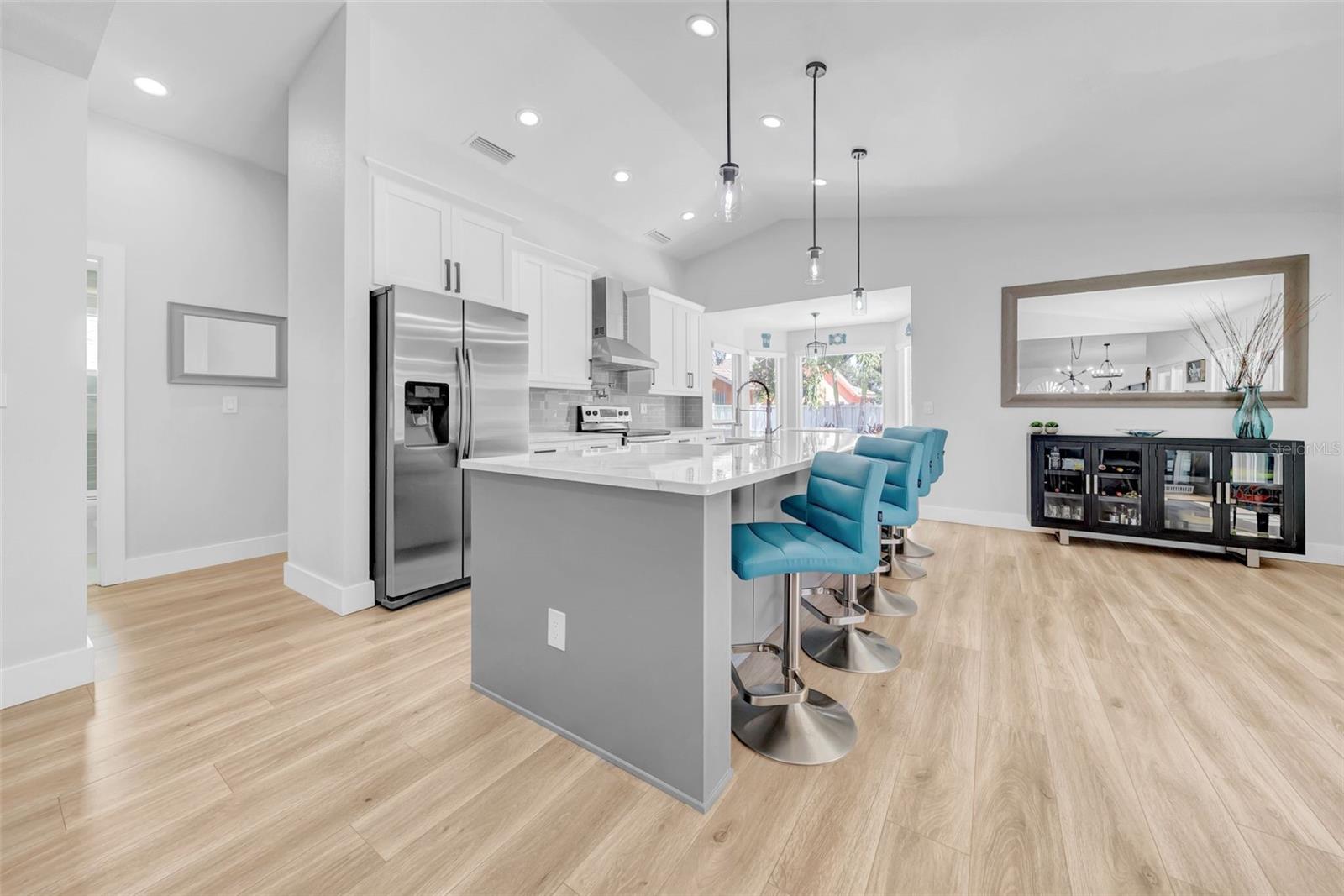 A chef's kitchen with stainless steel appliances, breakfast nook and an large island