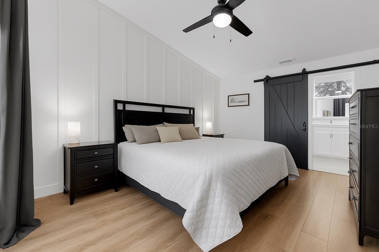 Spacious primary suite with sliding glass doors that open directly to the screened lanai