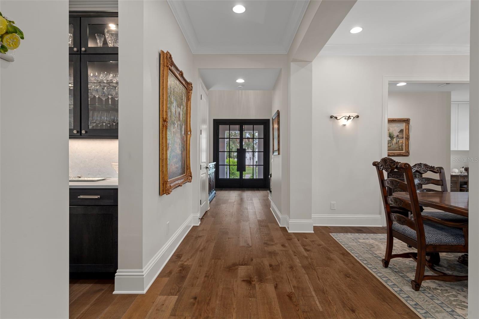 Foyer view back toward the front door. To the right is the formal dining room.  Gorgeous hand-scaped wood floors.