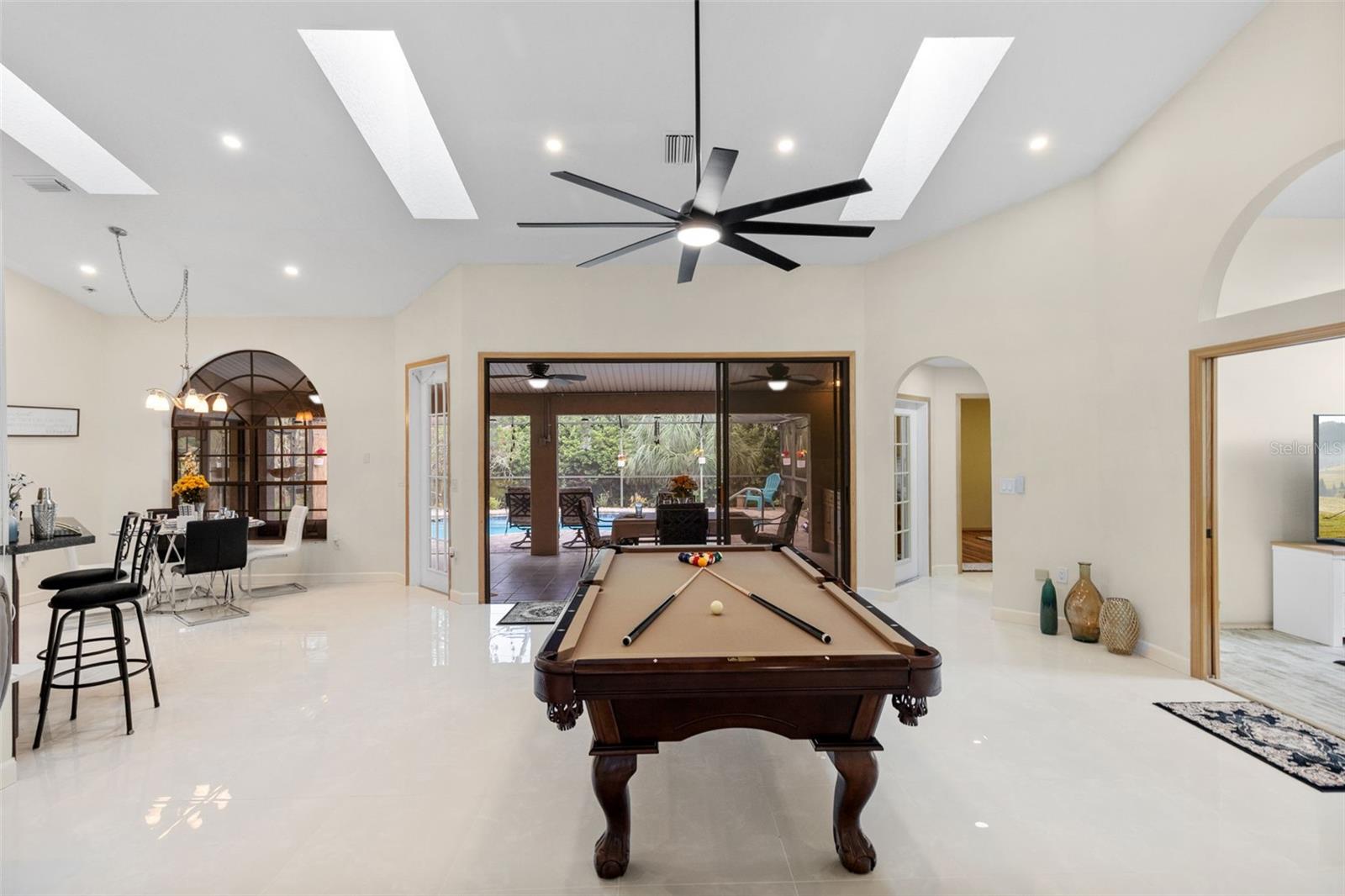 A seamless indoor–outdoor lifestyle unfolds in the screened lanai — a space designed for cooking, dining, and entertaining under the Florida sky.