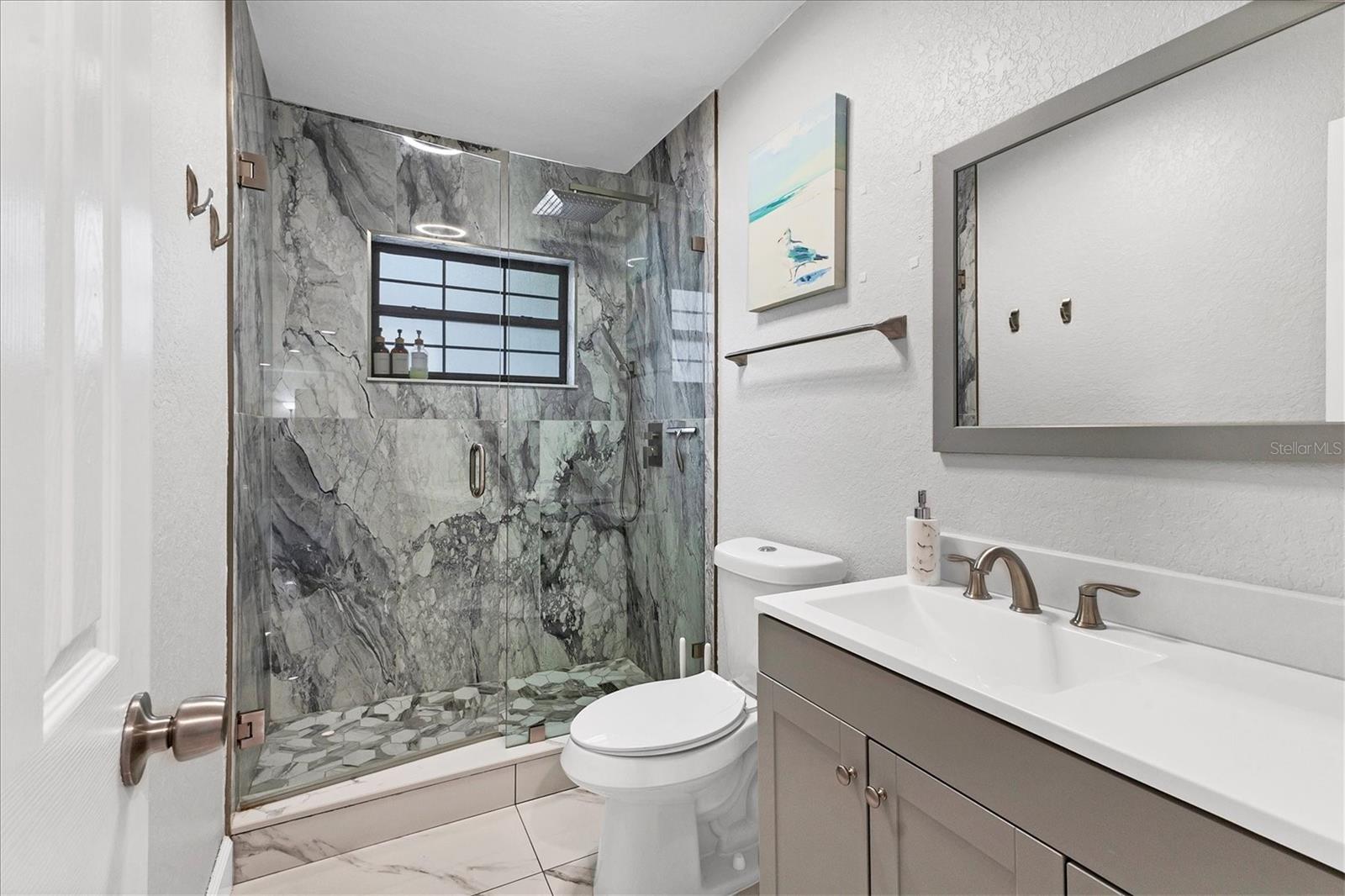 Situated between two bedrooms on the right side of the house, bathroom one offers a spacious vanity and dual flush toilet.