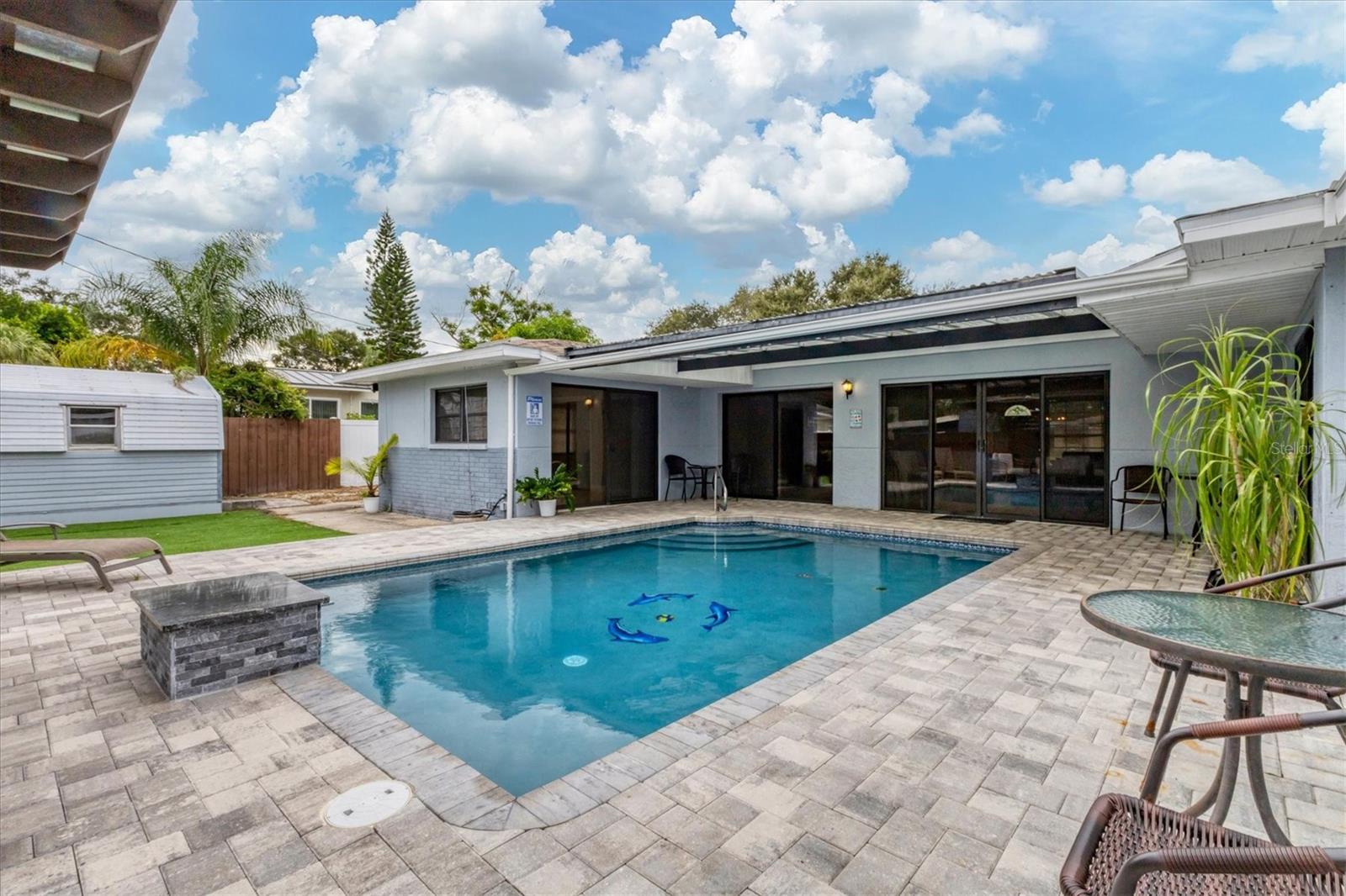 View of exterior looking into house from patio area. Large sliders open into the Great Room.  Far left sliders lead to bedroom 2/bathroom 1