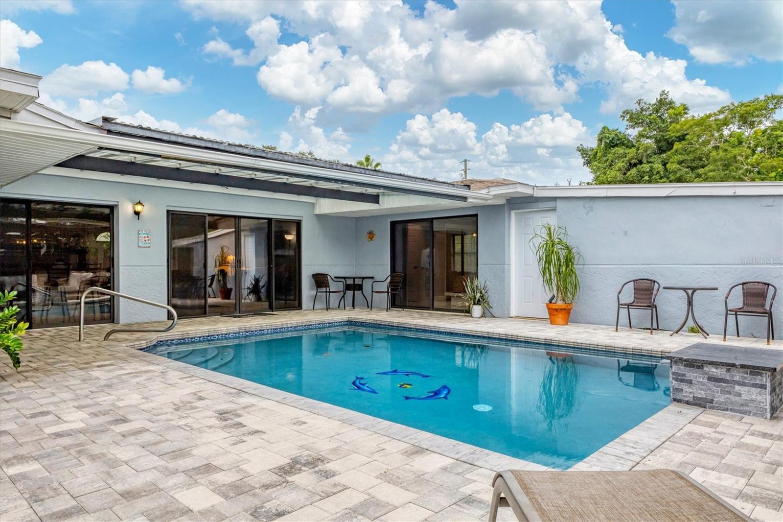 Pool is partially shaded.  Sliders on right lead into bedroom 2 and bathroom 2