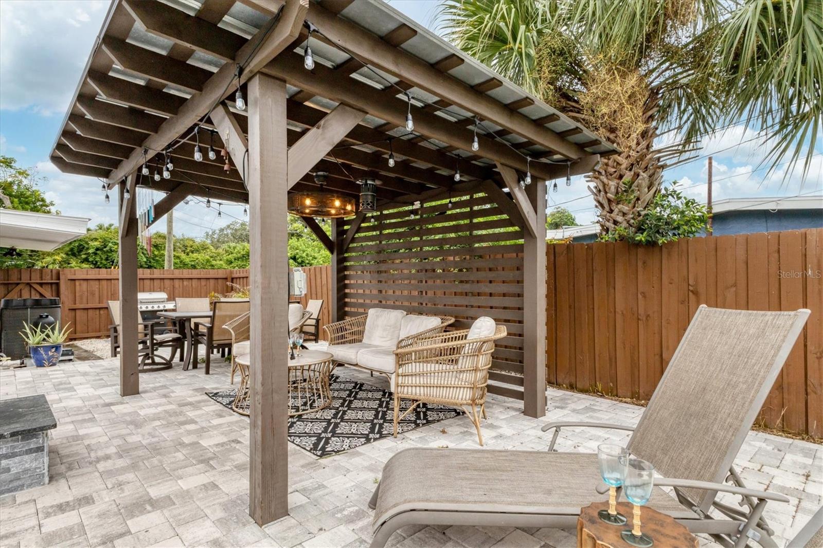 Outdoor living area with string lights and a fandalier