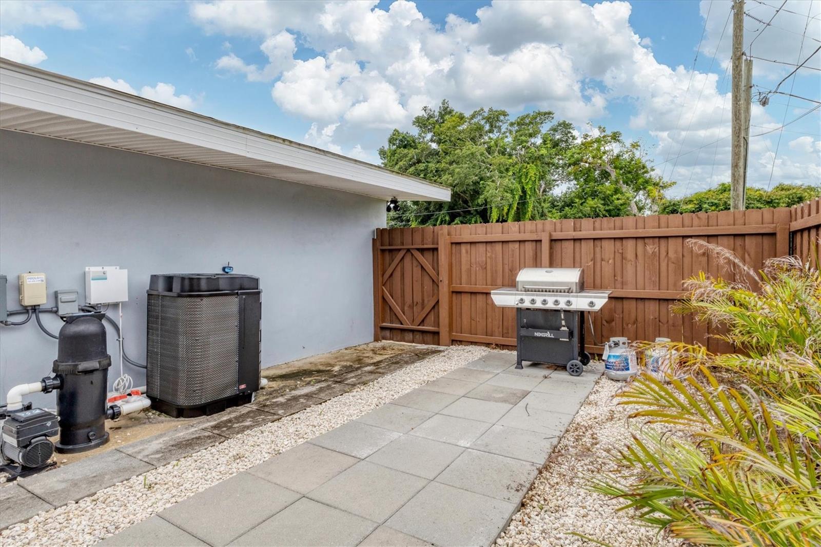 Pool heater and equipment installed in 2023.  Fence gate leads to side of house next to garage