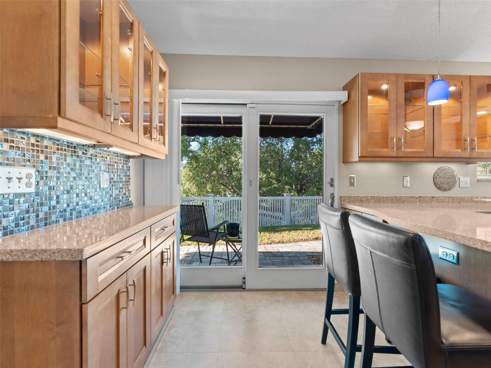 Built-in coffee bar and extra cabinetry with sliding glass doors that open to the backyard and serene pond views — the perfect spot to start your day