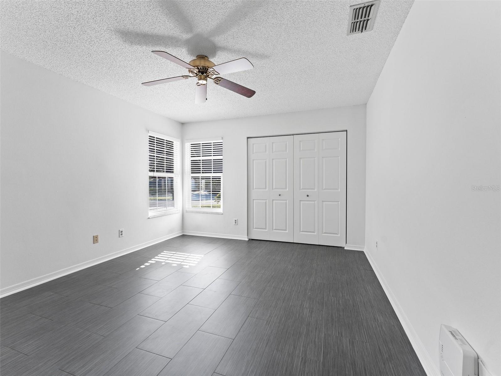 Generously sized second bedroom with tile flooring — bright, comfortable, and versatile