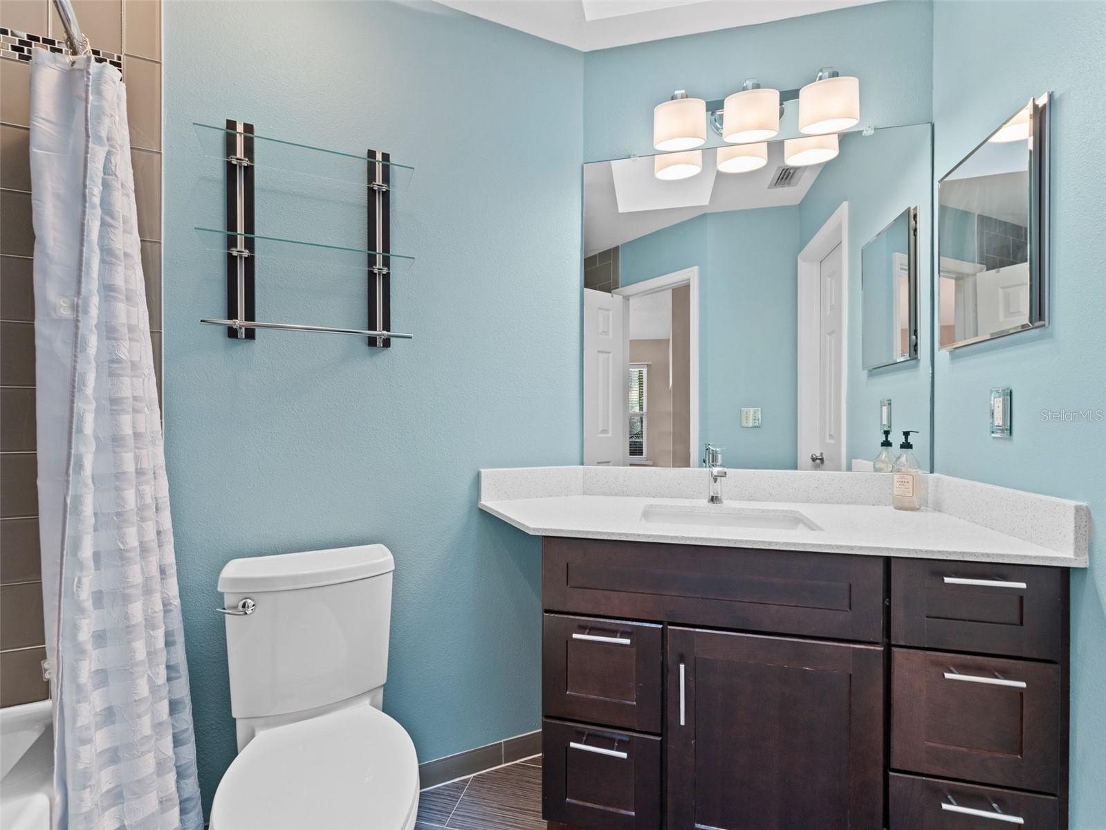 Modern hall bathroom featuring a spacious soaker tub/shower combo and stylish finishes — comfort meets functionality