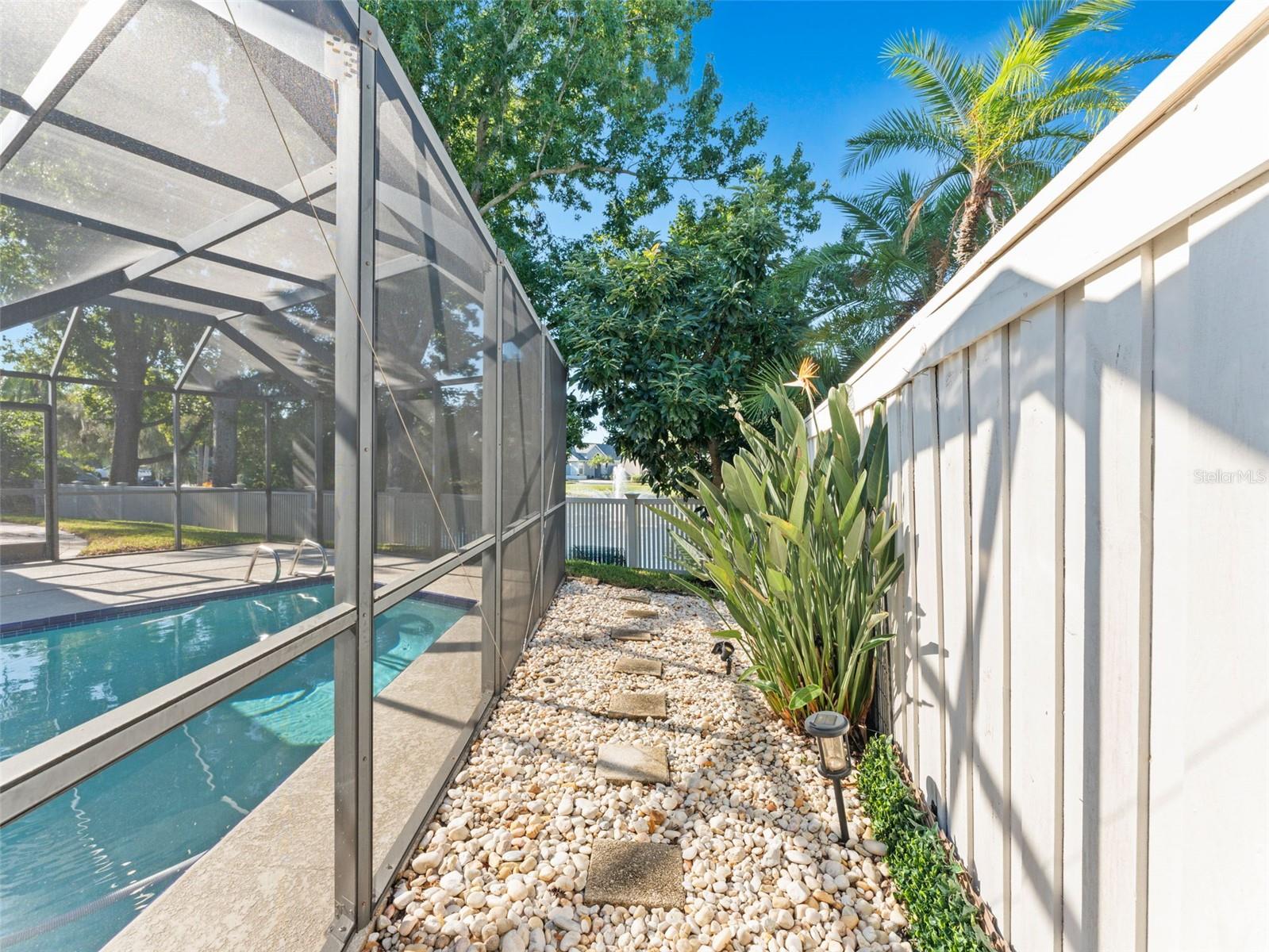 Scenic walkway around the pool with decorative stones and landscaping — a stylish path for enjoying your outdoor oasis
