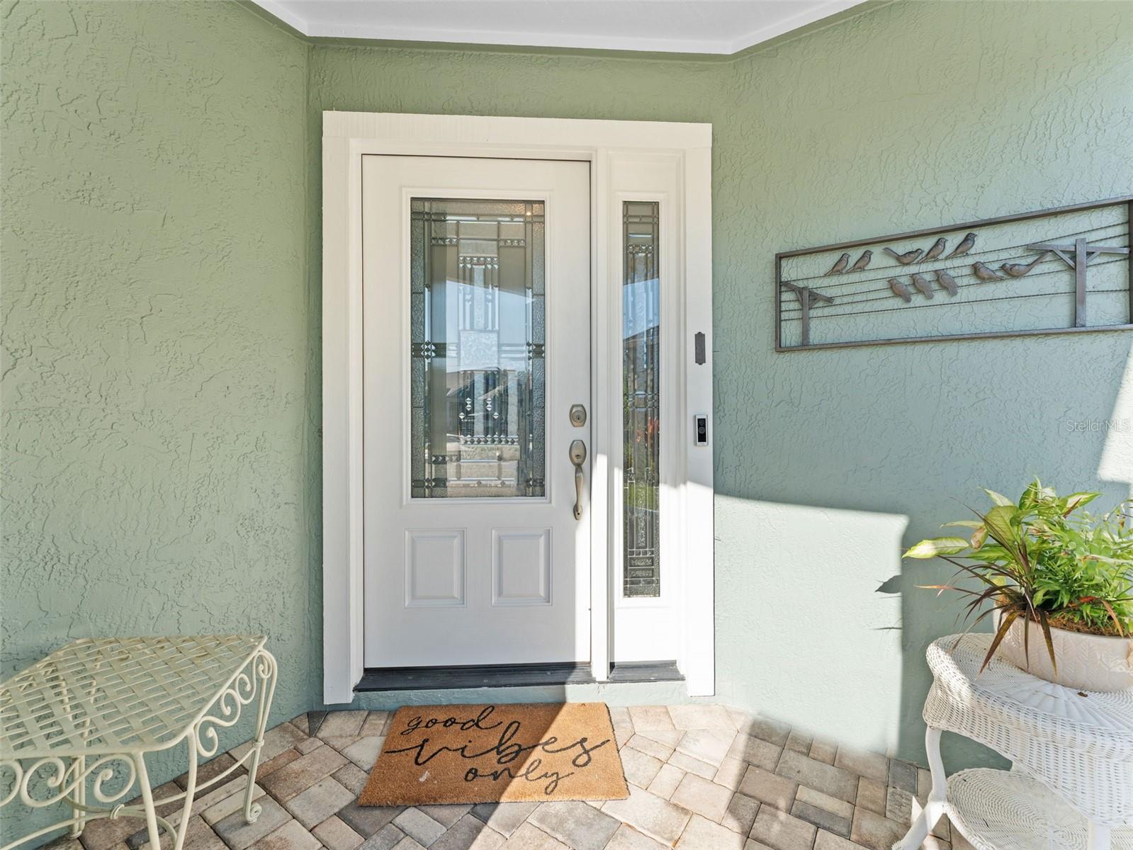 A warm welcome awaits with a charming front porch and beautiful entry door