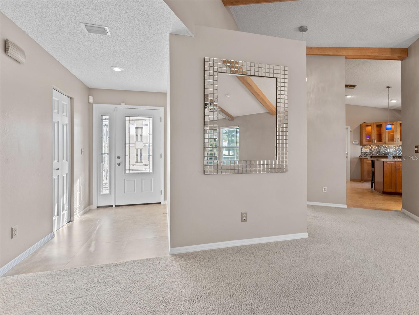 Looking back toward the welcoming foyer, the vaulted ceilings create an open, airy feel throughout the home