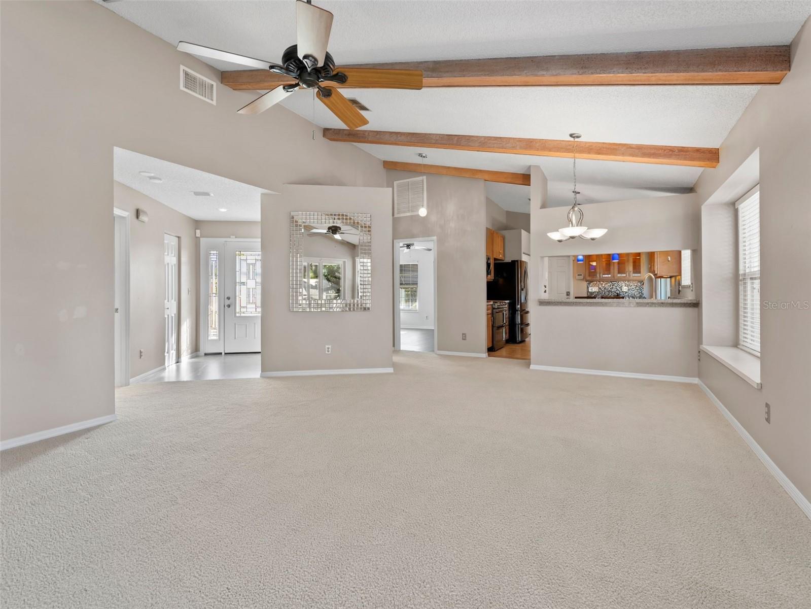 Tasteful wood beams highlight the vaulted ceiling, adding warmth and character to the living room