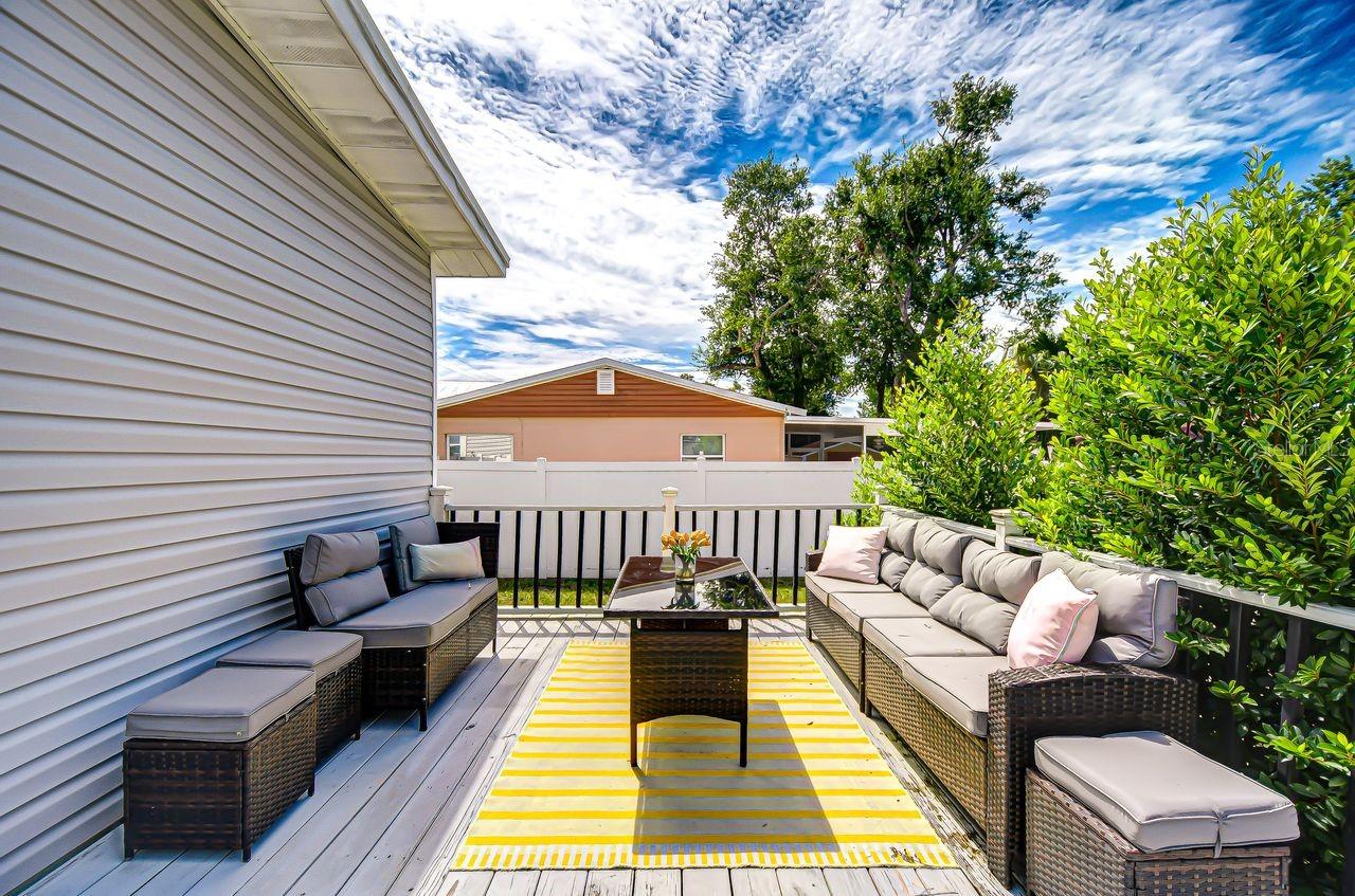 The spacious back deck is perfect for entertaining, complete with comfortable seating and lush greenery for privacy. It’s an ideal spot to gather with friends or enjoy a quiet evening outdoors.