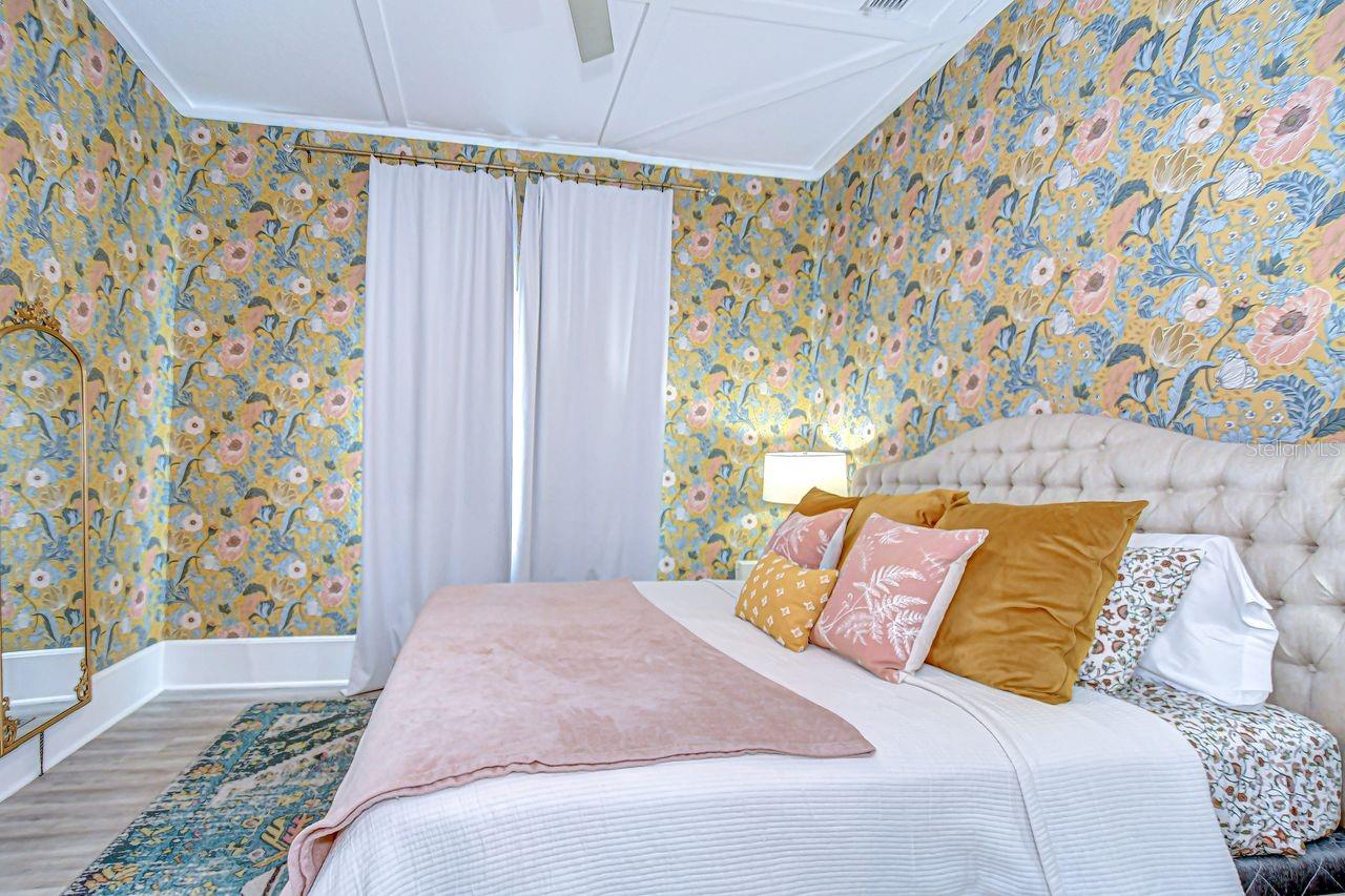 The primary bedroom offers a bold and stylish retreat with vibrant floral wallpaper