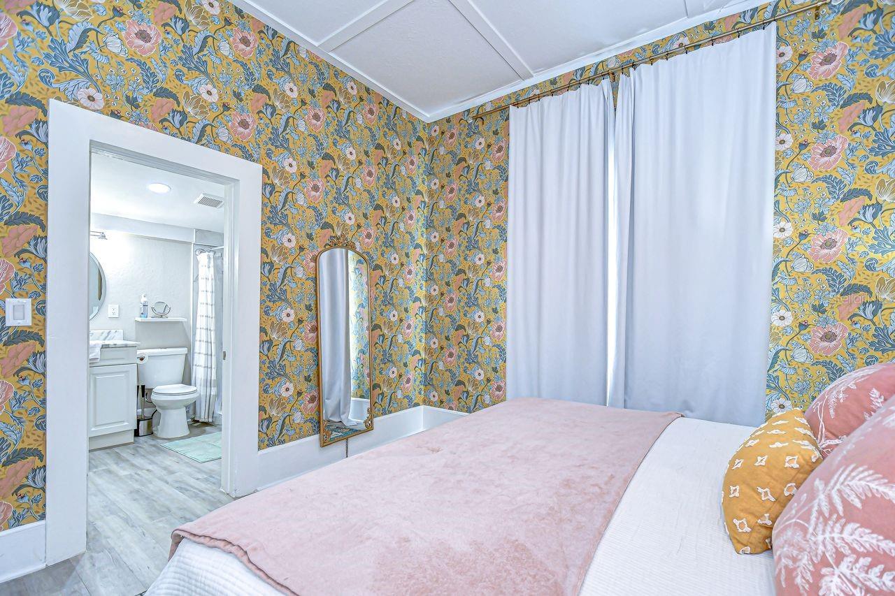 The primary suite includes a colorful and inviting bedroom with an ensuite bath for added privacy.