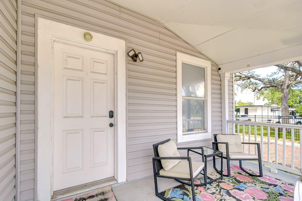 The inviting front porch provides a cozy spot to relax, complete with seating and neighborhood views. Perfect for enjoying morning coffee or unwinding at the end of the day.