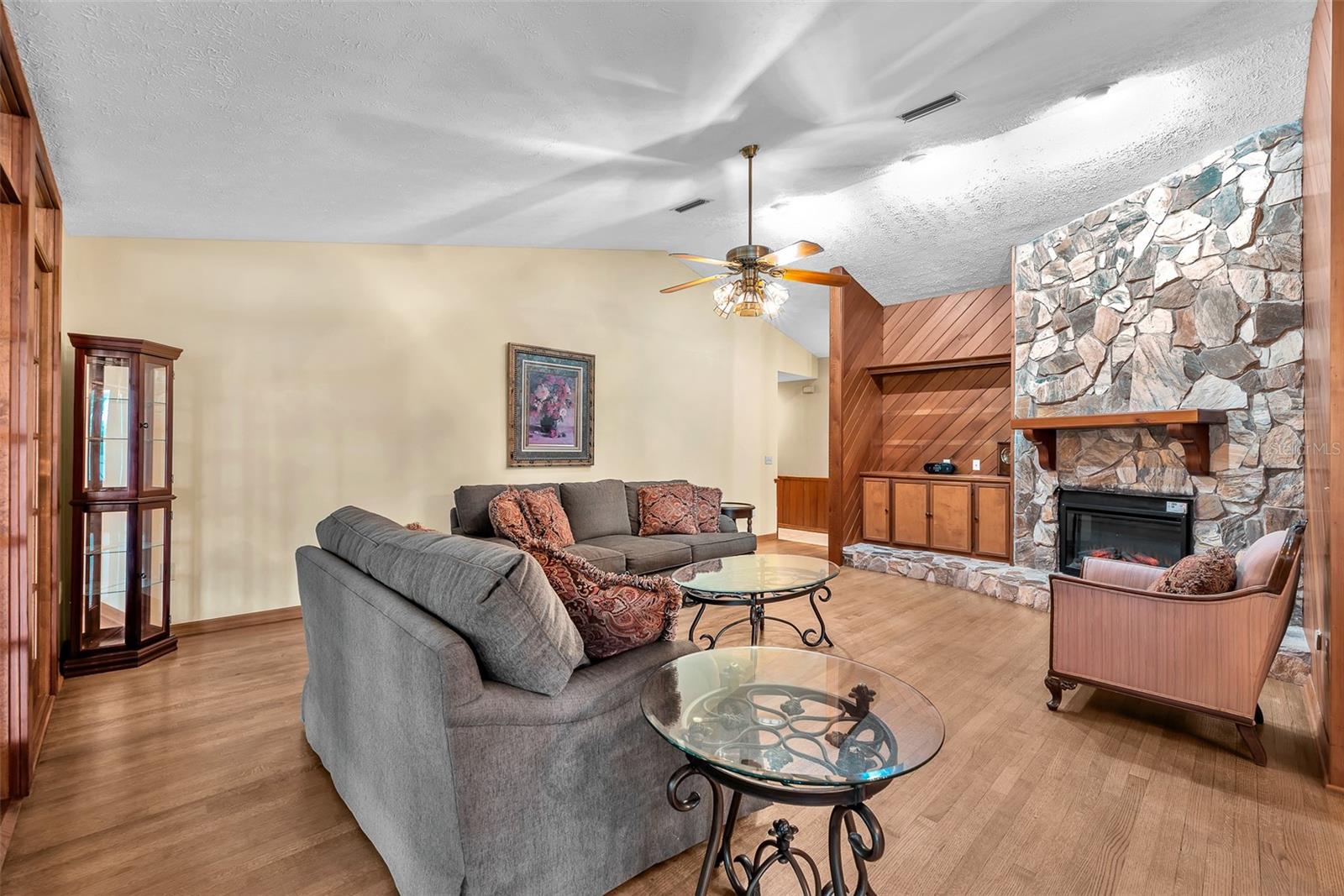 The cathedral ceiling, oak floors, stone fireplace surround, and the cedar planked walls are timeless finishes reflecting quality craftsmanship throughout.