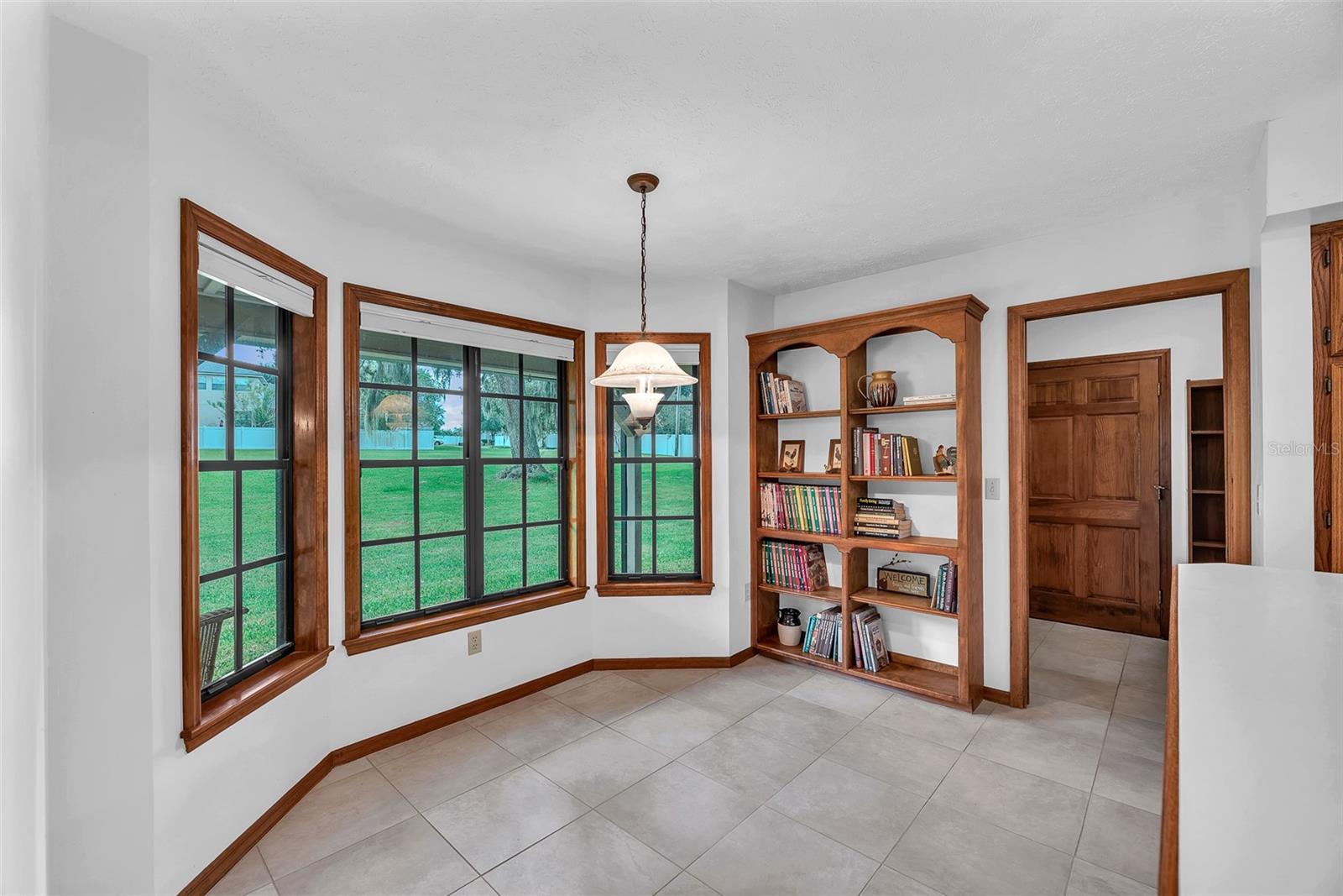 Custom built solid oak shelves and access to the mudroom with laundry and a 3rd full bathroom are next to the dinette behind a pocket door.