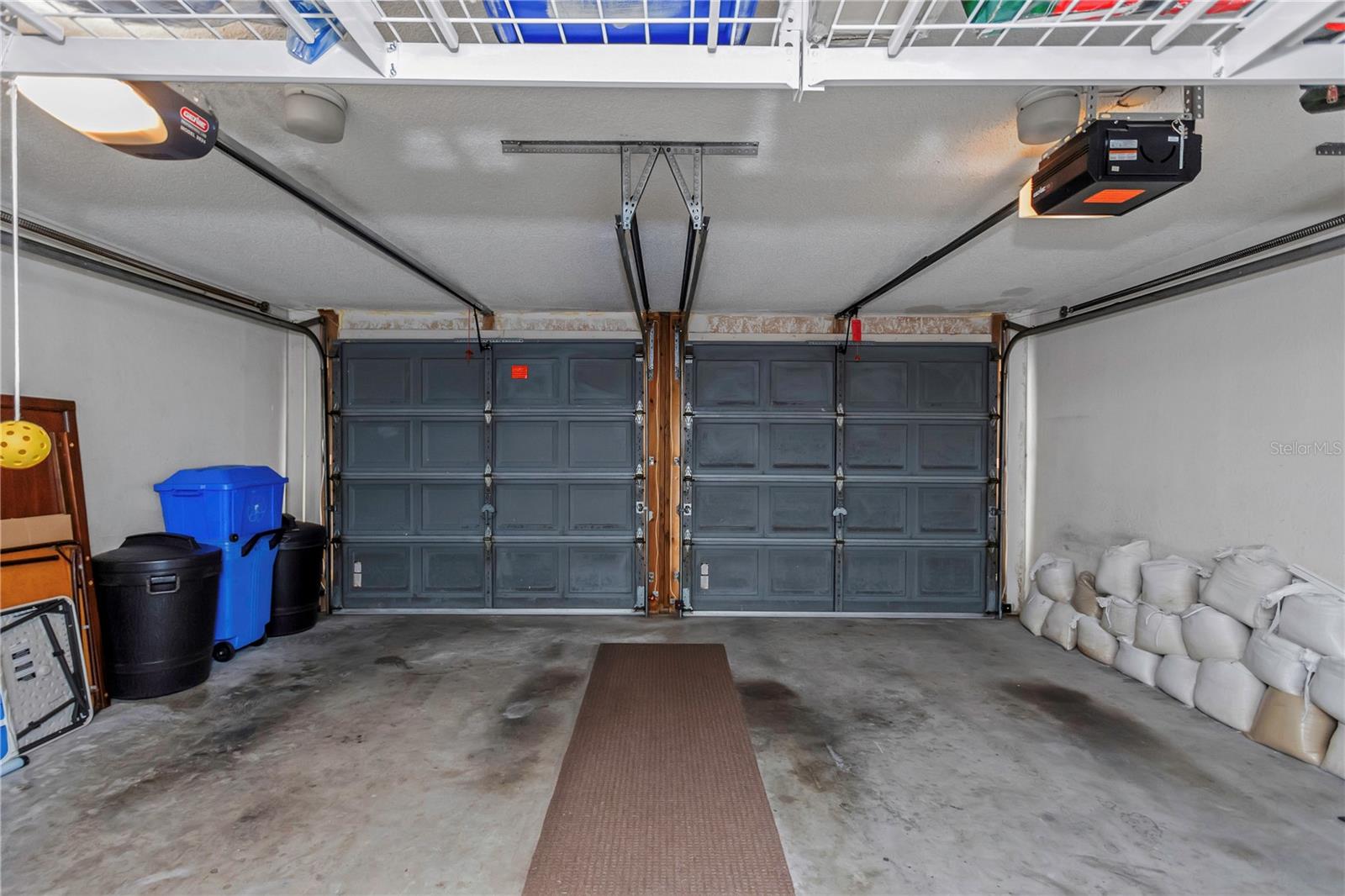 Sizable 2-car garage with overhead storage racks.